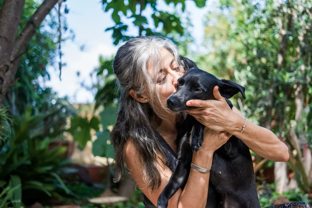 older woman holding her dog affectionately