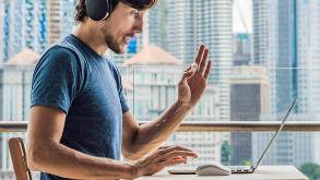 man-balcony-laptop-video-chat-870x490