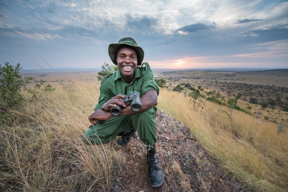 Smiling field guide holding binoculars