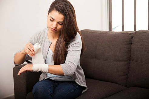 female wrapping hand with gauze