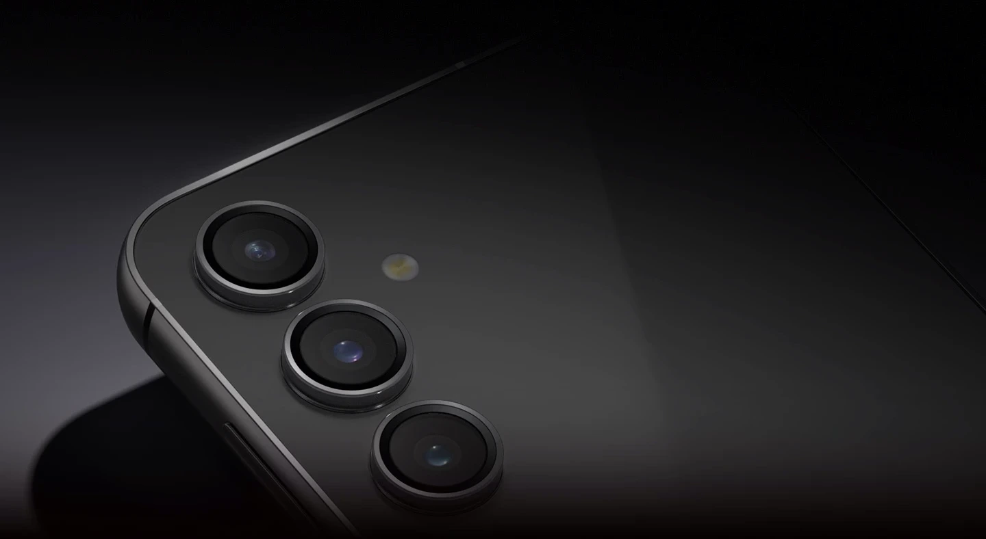 Un dispositivo Galaxy S23 FE en Graphite apoyado sobre la parte delantera para mostrar la cámara posterior con luz tenue.