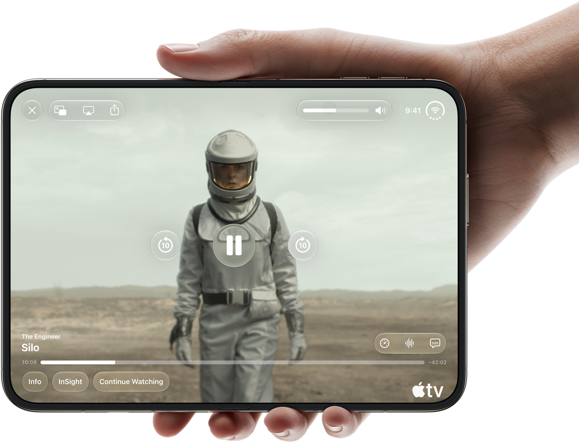 iPhone Duo, lo sostiene una mano, abierto en posición horizontal, completamente desplegado, la pantalla interior muestra la serie "Silo" de Apple TV