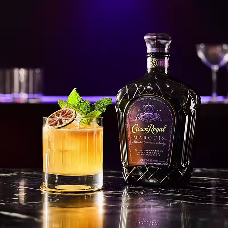 Crown Royal Marquis bottle with Royal Passion Punch cocktail.