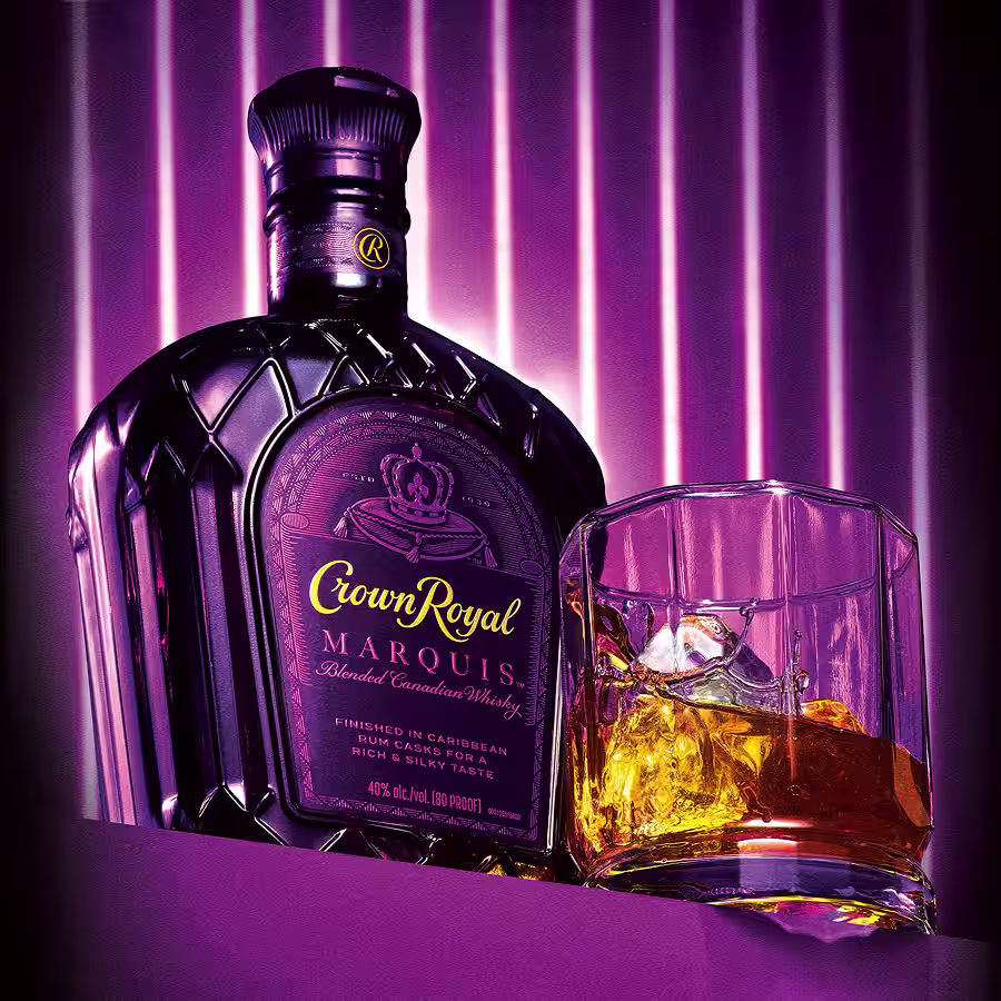 A bottle of Crown Royal Marquis next to a glass of whisky in a glass