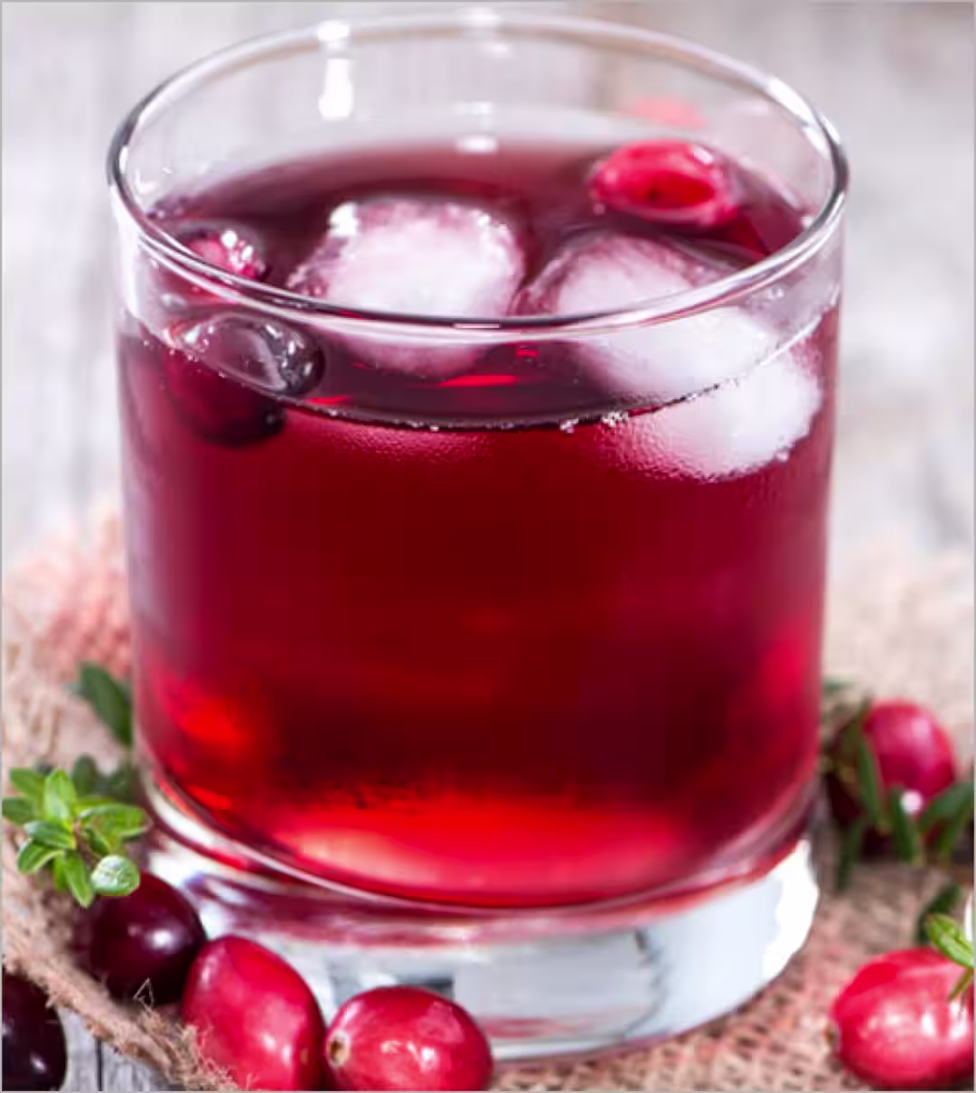 A Crown Royal Black and Cranberry cocktail garnished with cranberries on a table
