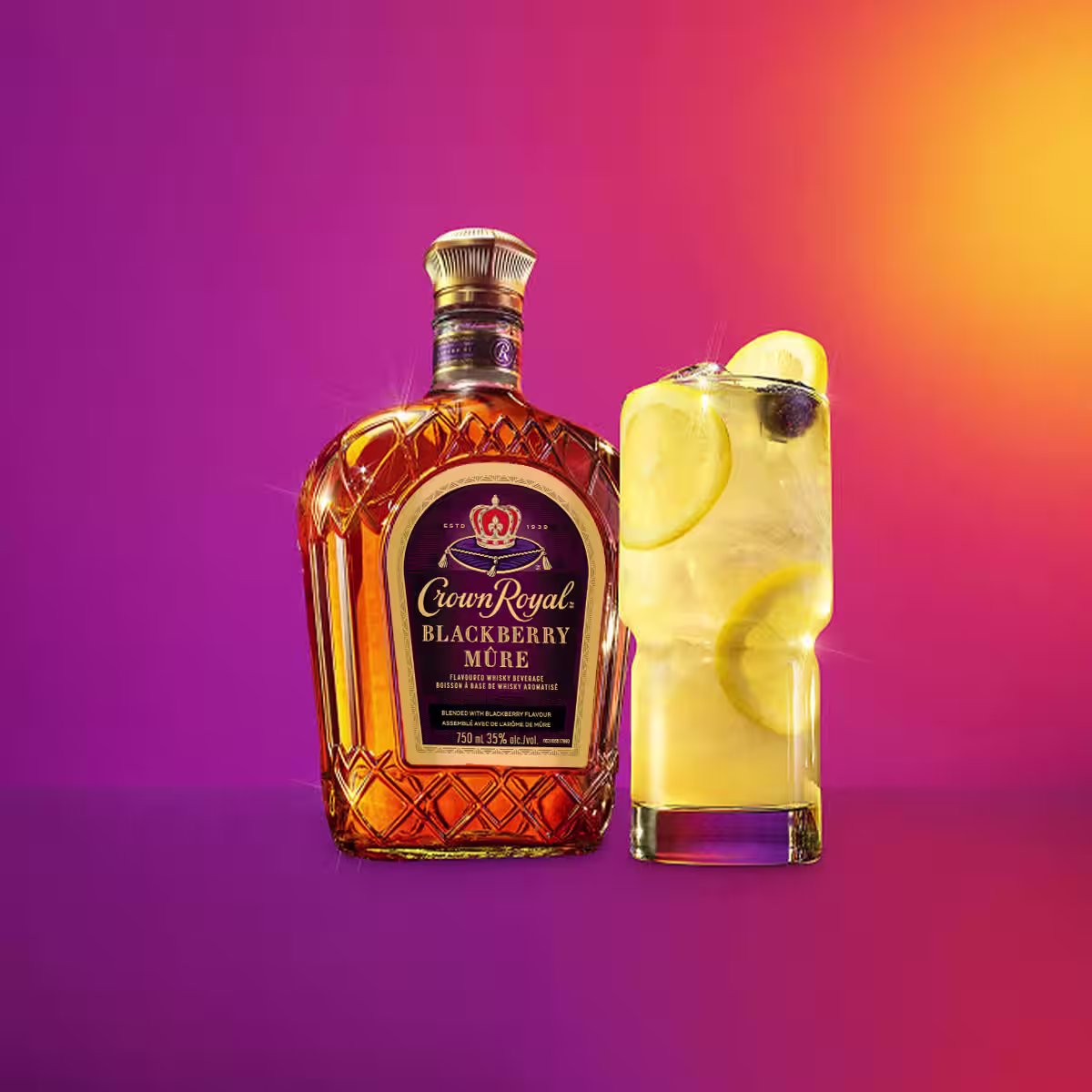 A bottle of Crown Royal Blackberry next to a blackberry lemonade cocktail