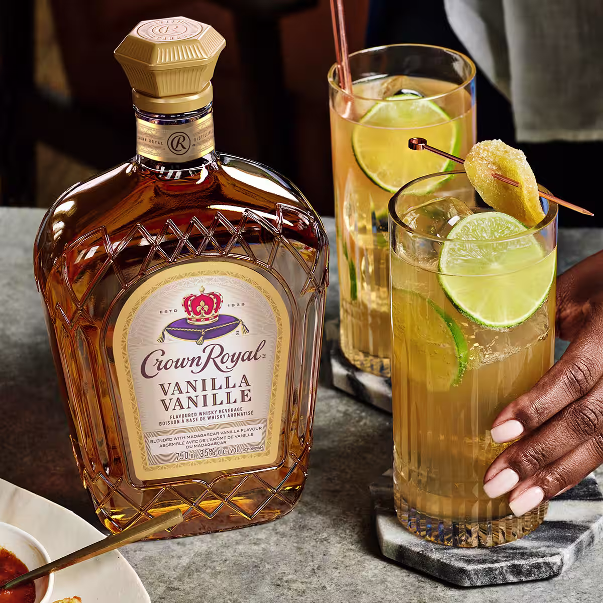 Two Hard Ginger Ale cocktails on a table next to a bottle of Crown Royal Vanilla