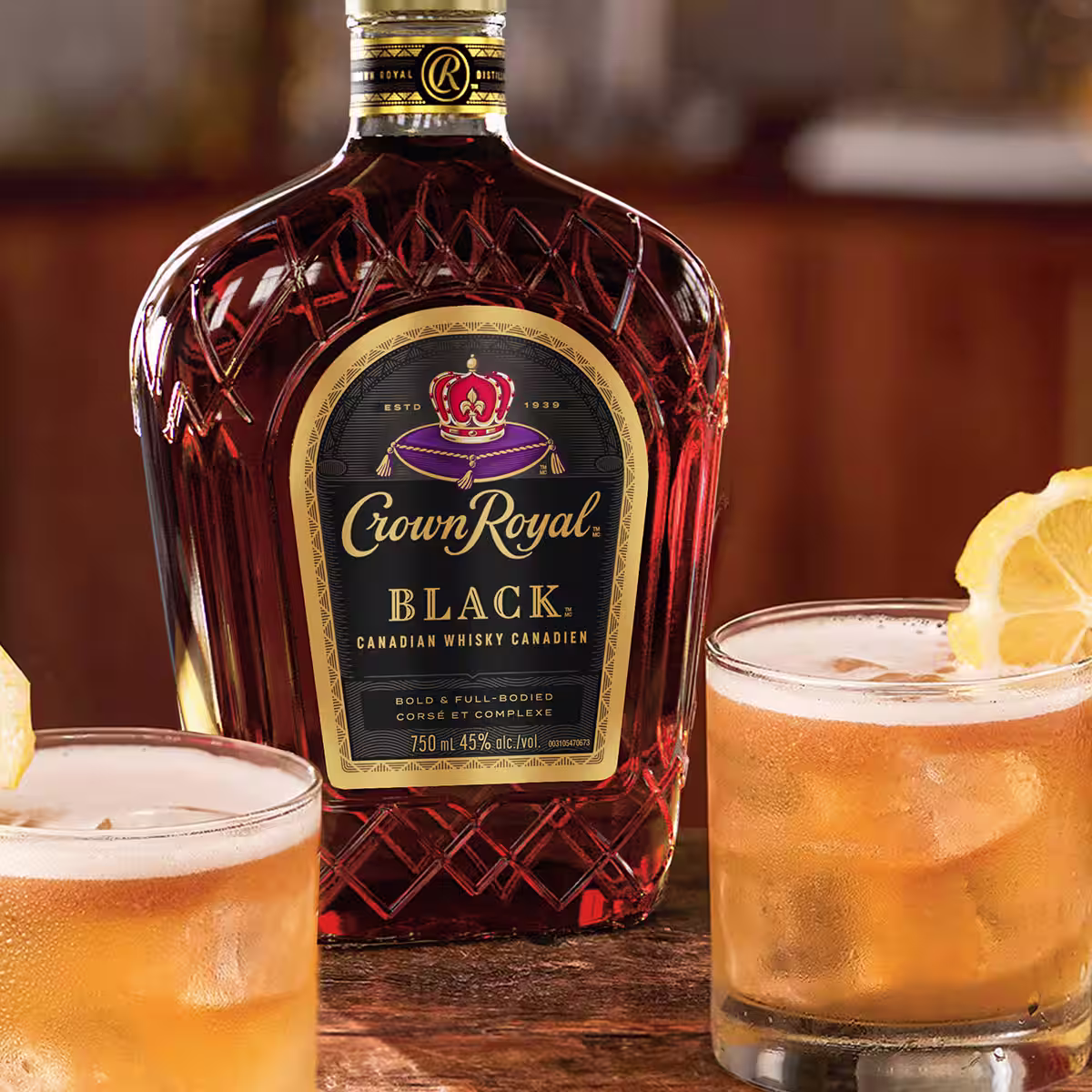 A bottle of Crown Royal Black next to a two Black Whisky Sour cocktails