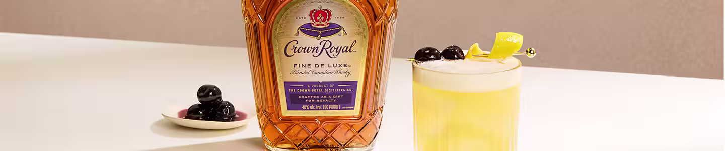 there is a bottle of whisky sitting on a table next to a glass