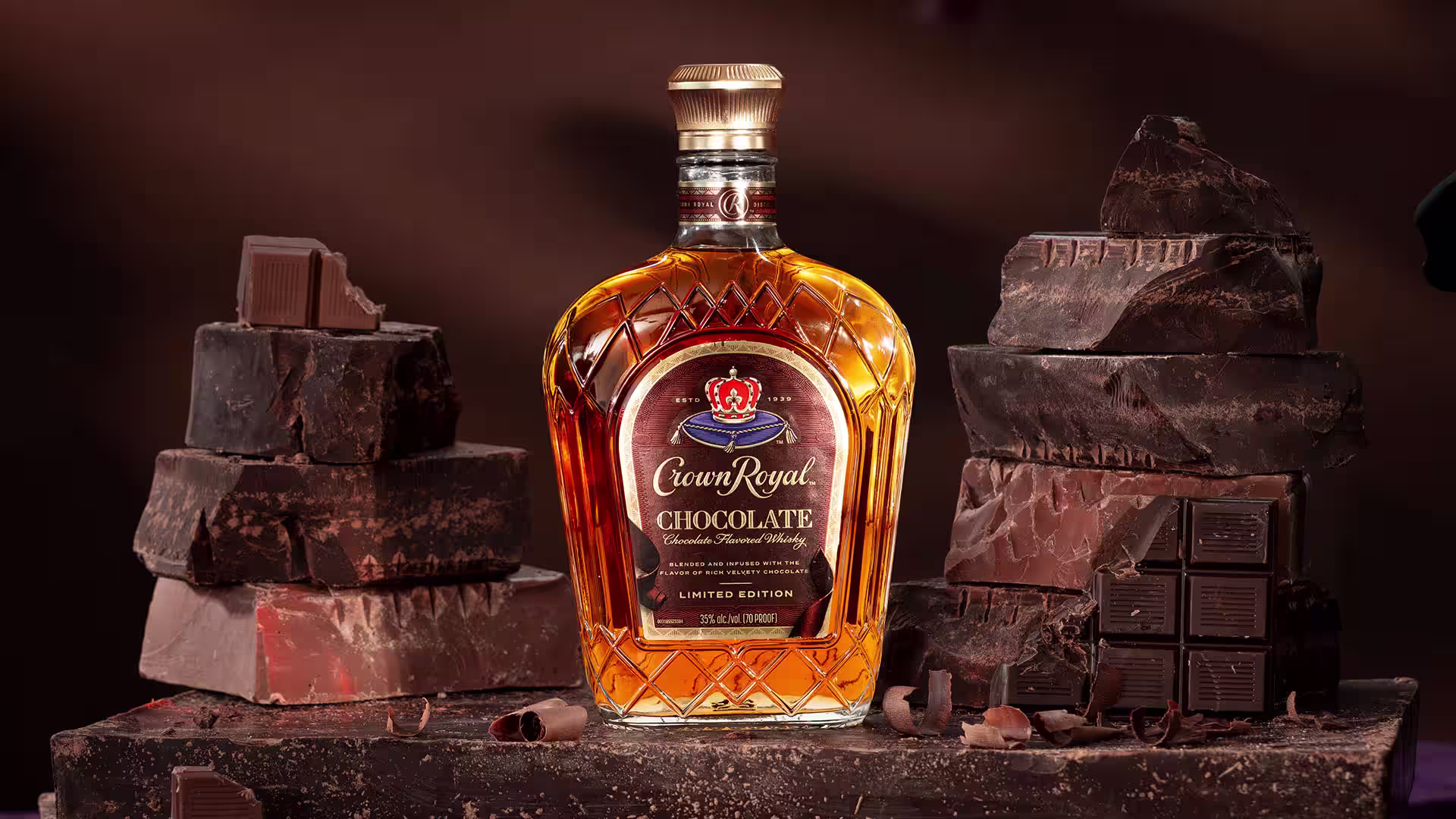 A bottle of Crown Royal Chocolate Flavored Whisky surrounded by chocolate chunks