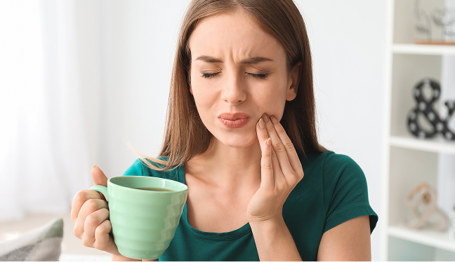 Person with sensitive teeth drinking coffee