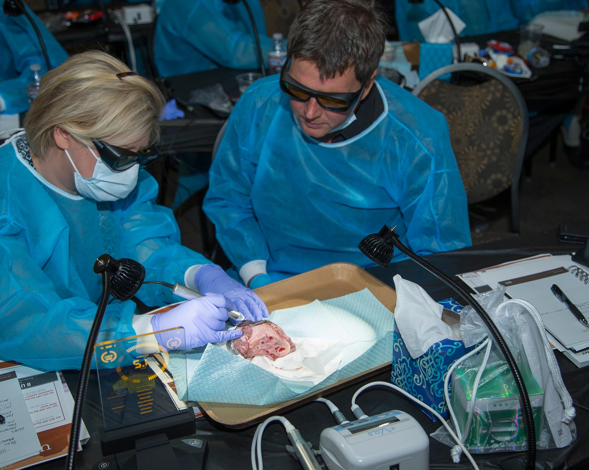 Dentists in scrubs using a drill