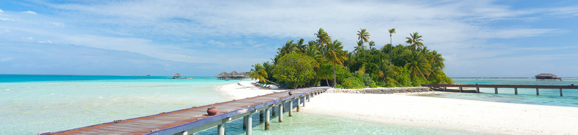 Holzsteg führt zu kleiner Malediven Insel