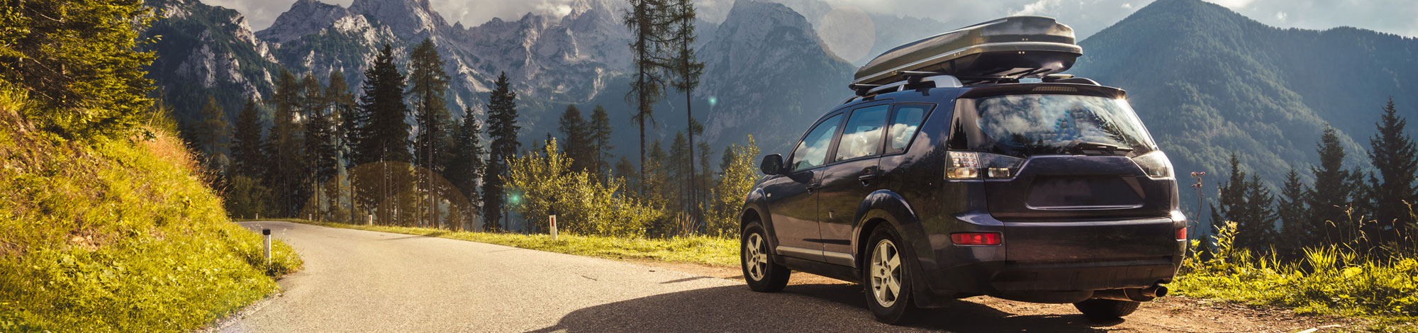 Auto steht auf einer Straße vor Bergkulisse