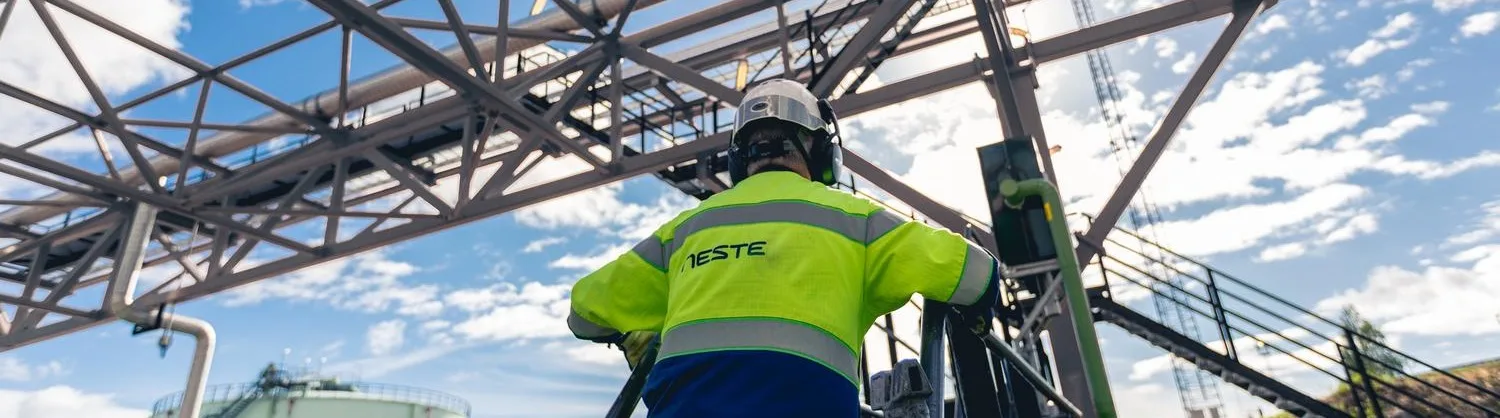 Neste employee and pipelines of the Porvoo refinery.