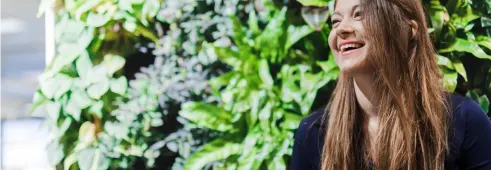 Woman laughing against a green wall