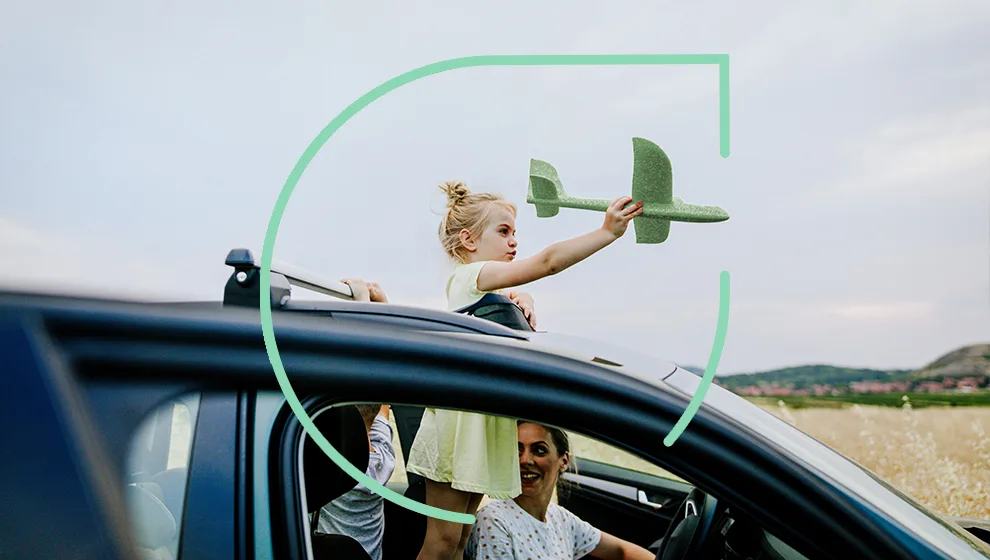 Girl in a parked car playing with toy green airplane out of the window