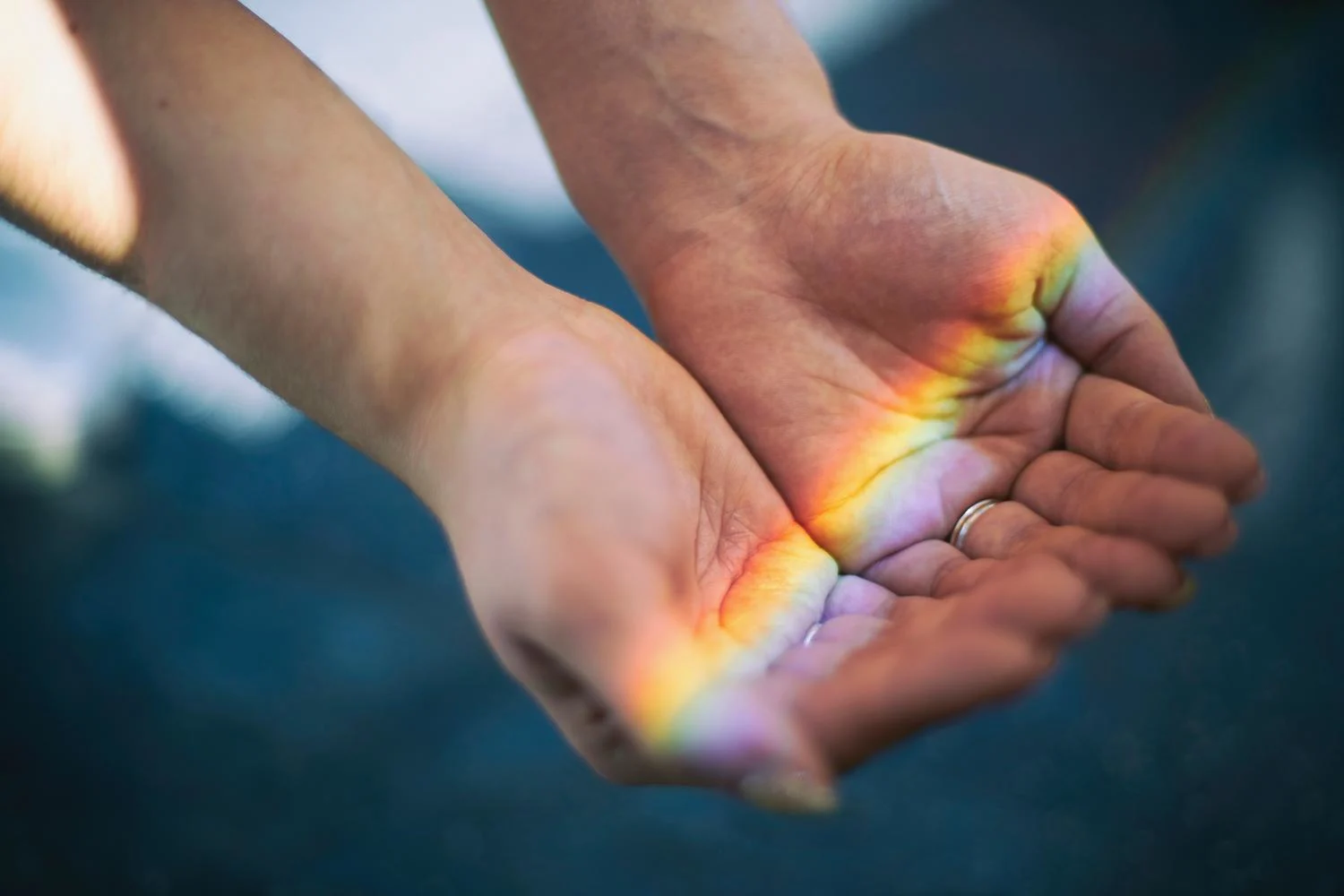 Rainbow lights falling on hands