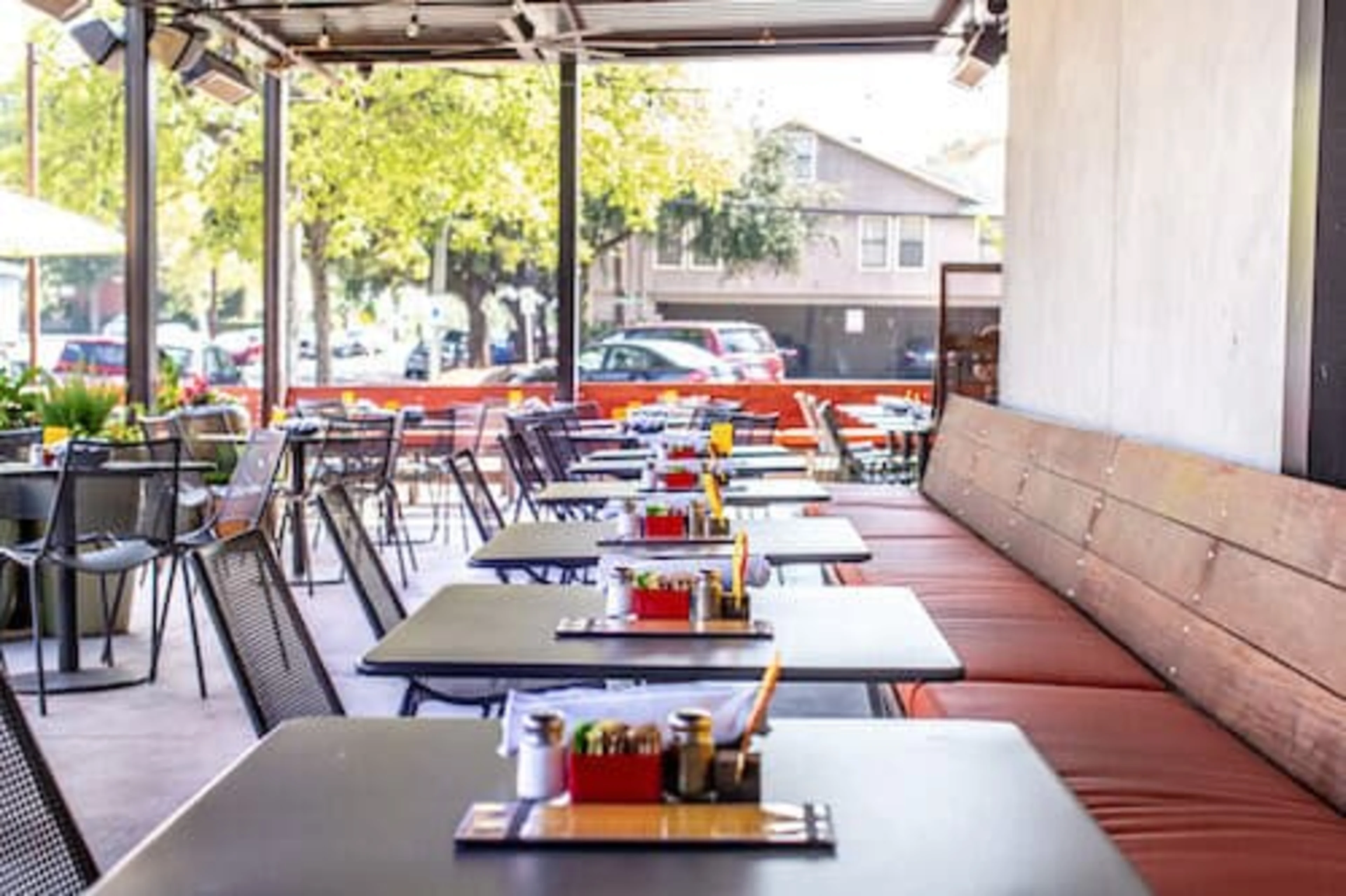 An empty patio with long red benches and tables.