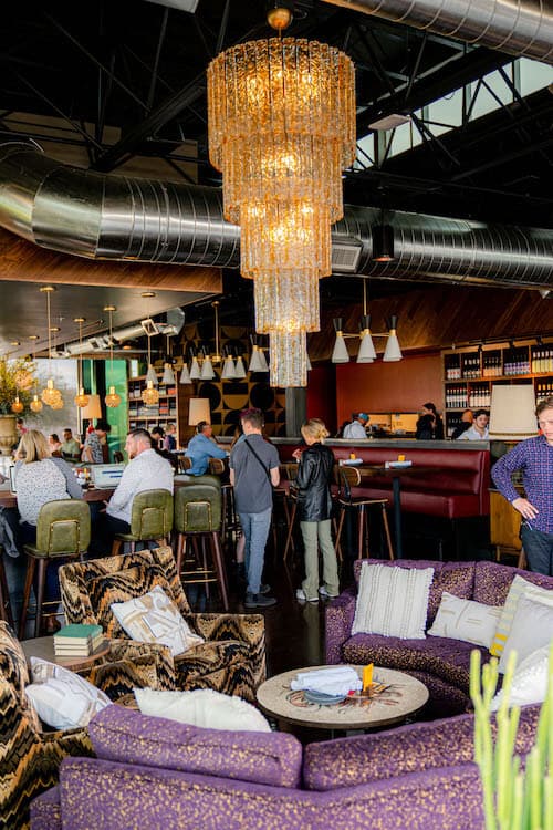 A large purple table with a glass chandelier hanging over it.