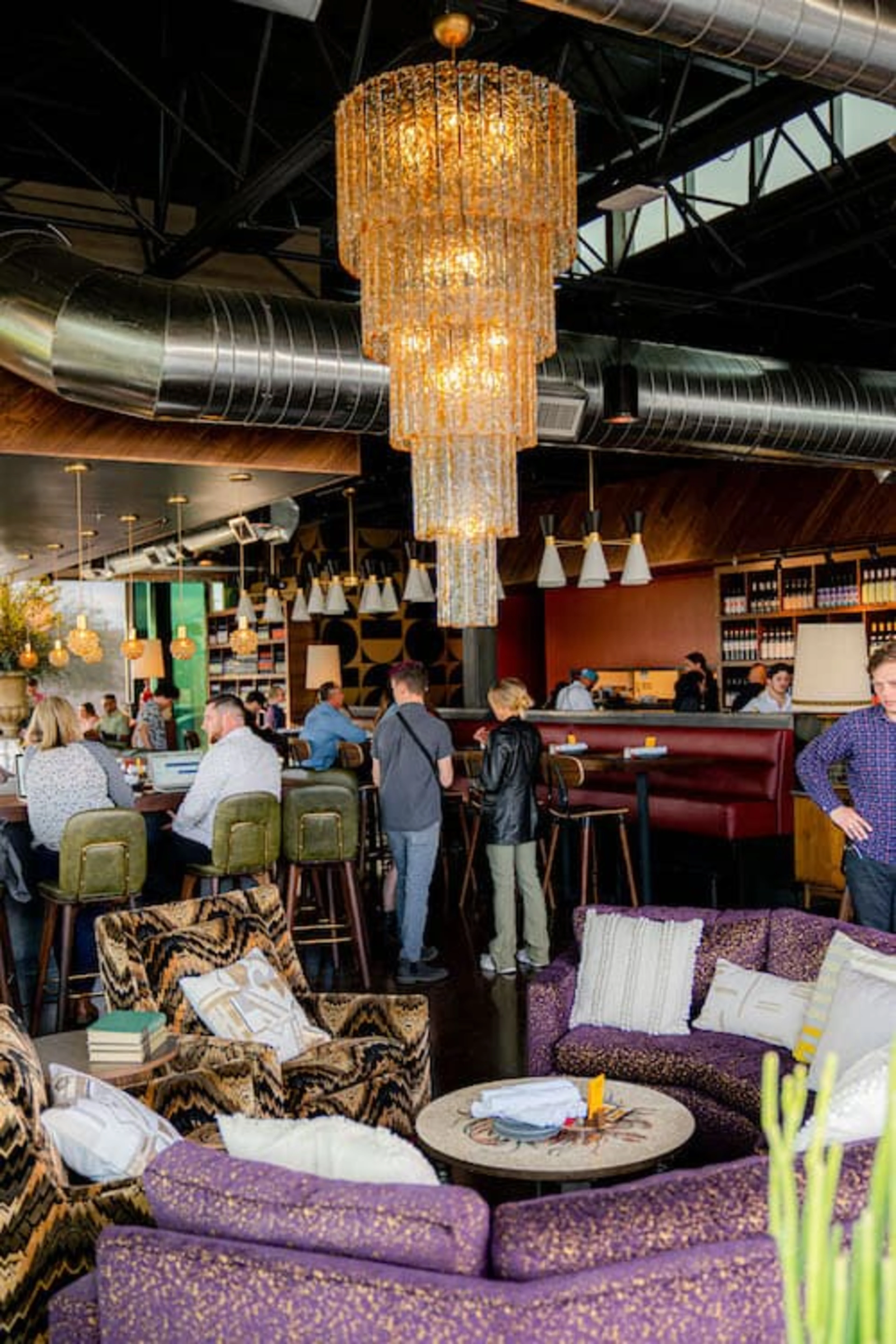 A large purple table with a glass chandelier hanging over it.