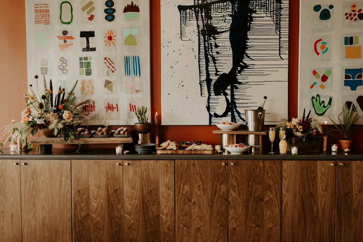 A wooden side table with food and flowers.