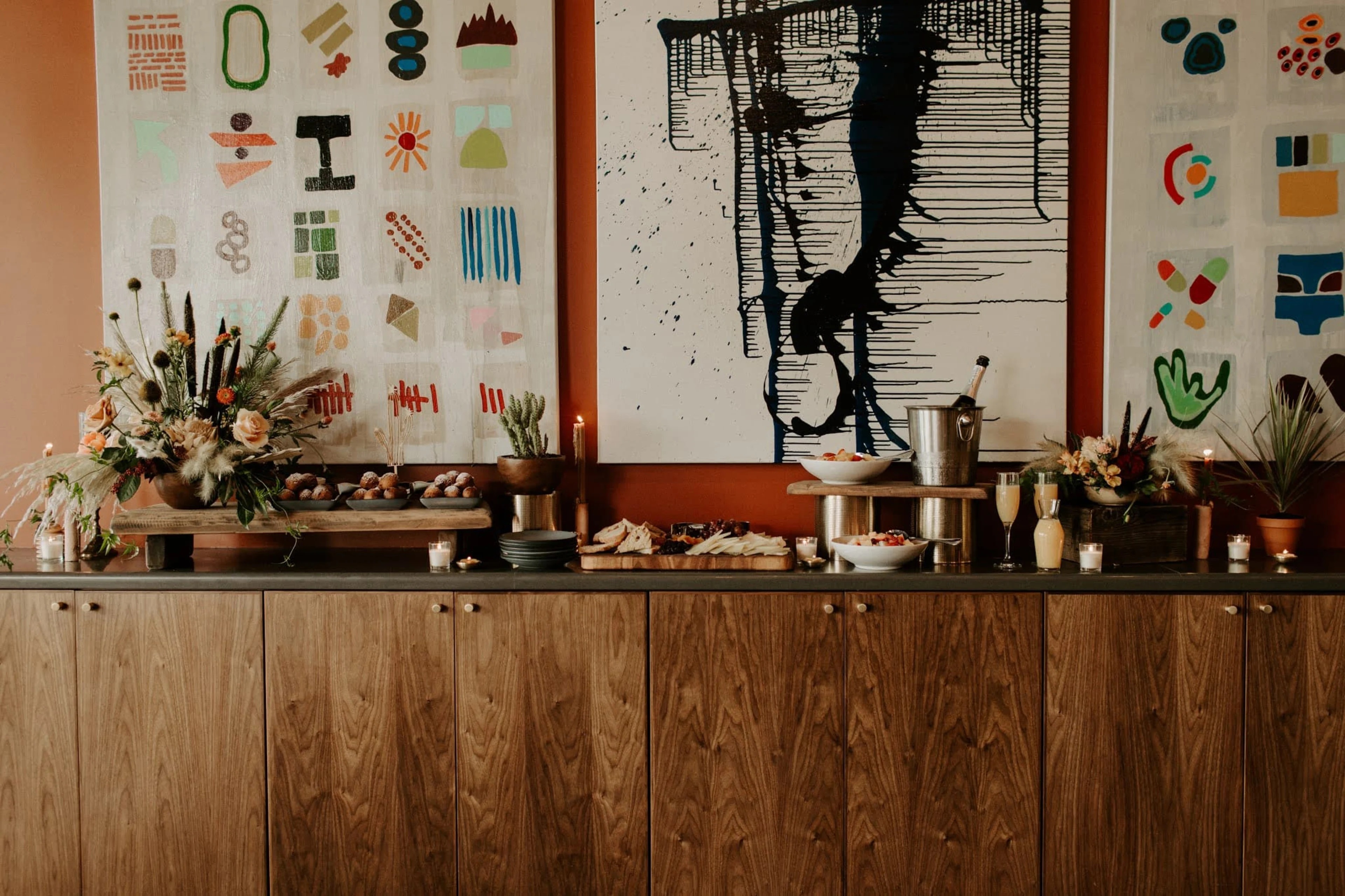 A wooden side table with food and flowers.