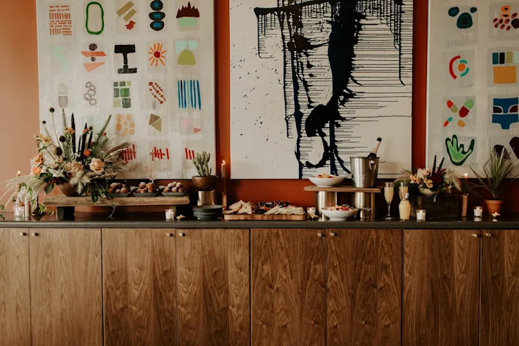 A wooden side table with food and flowers.