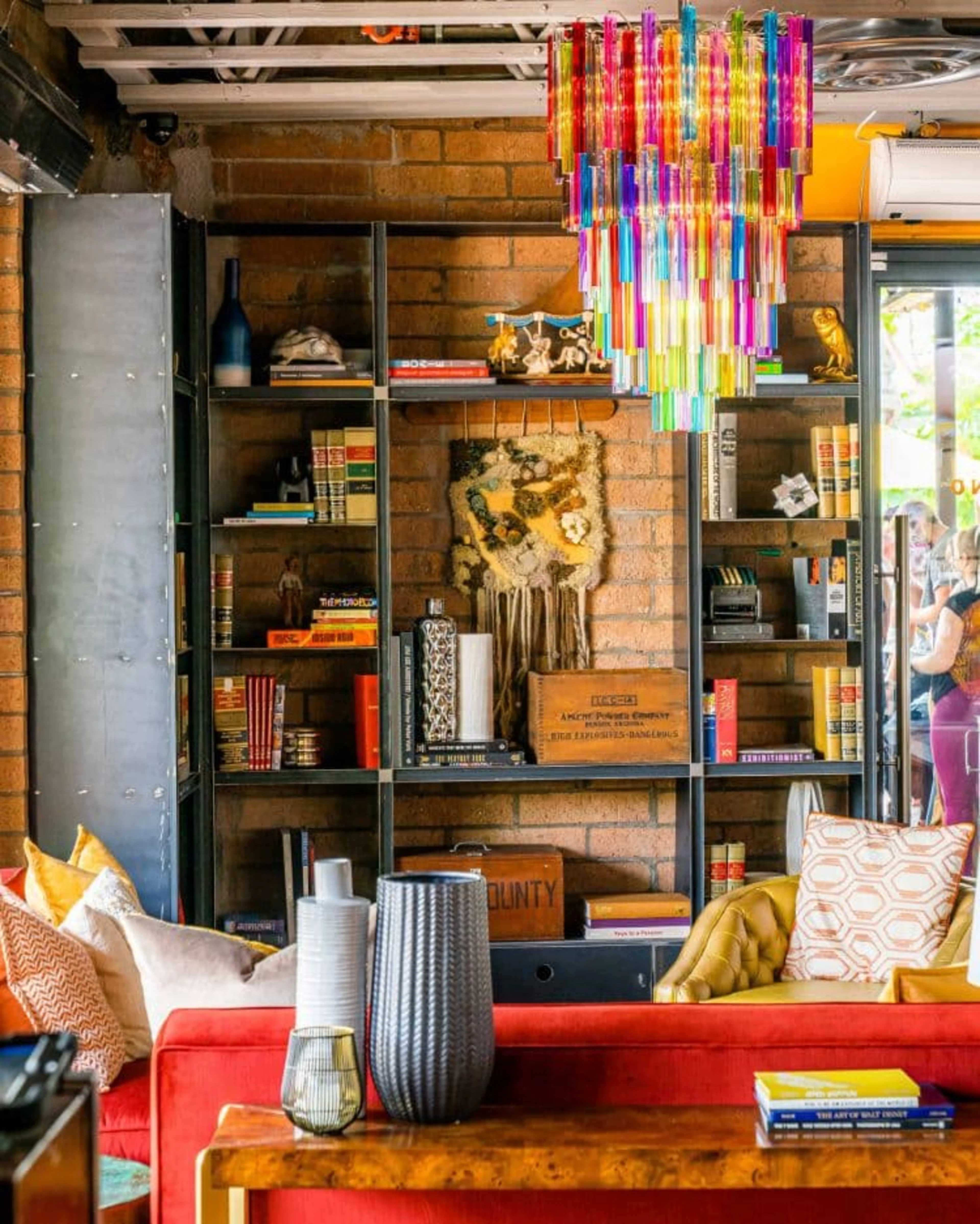 A colorful glass chandelier with a red table.