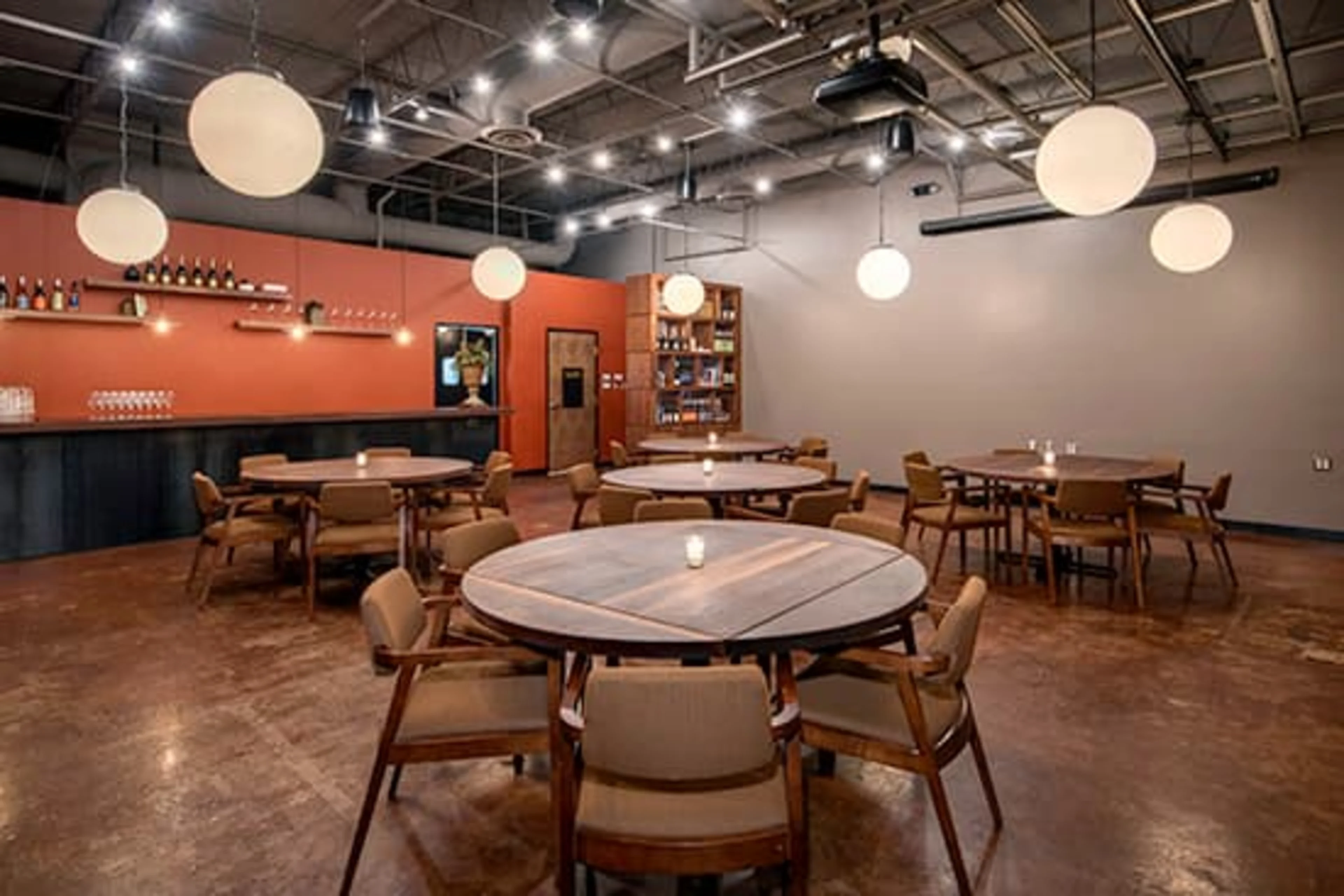 Round wooden tables with round lights above.