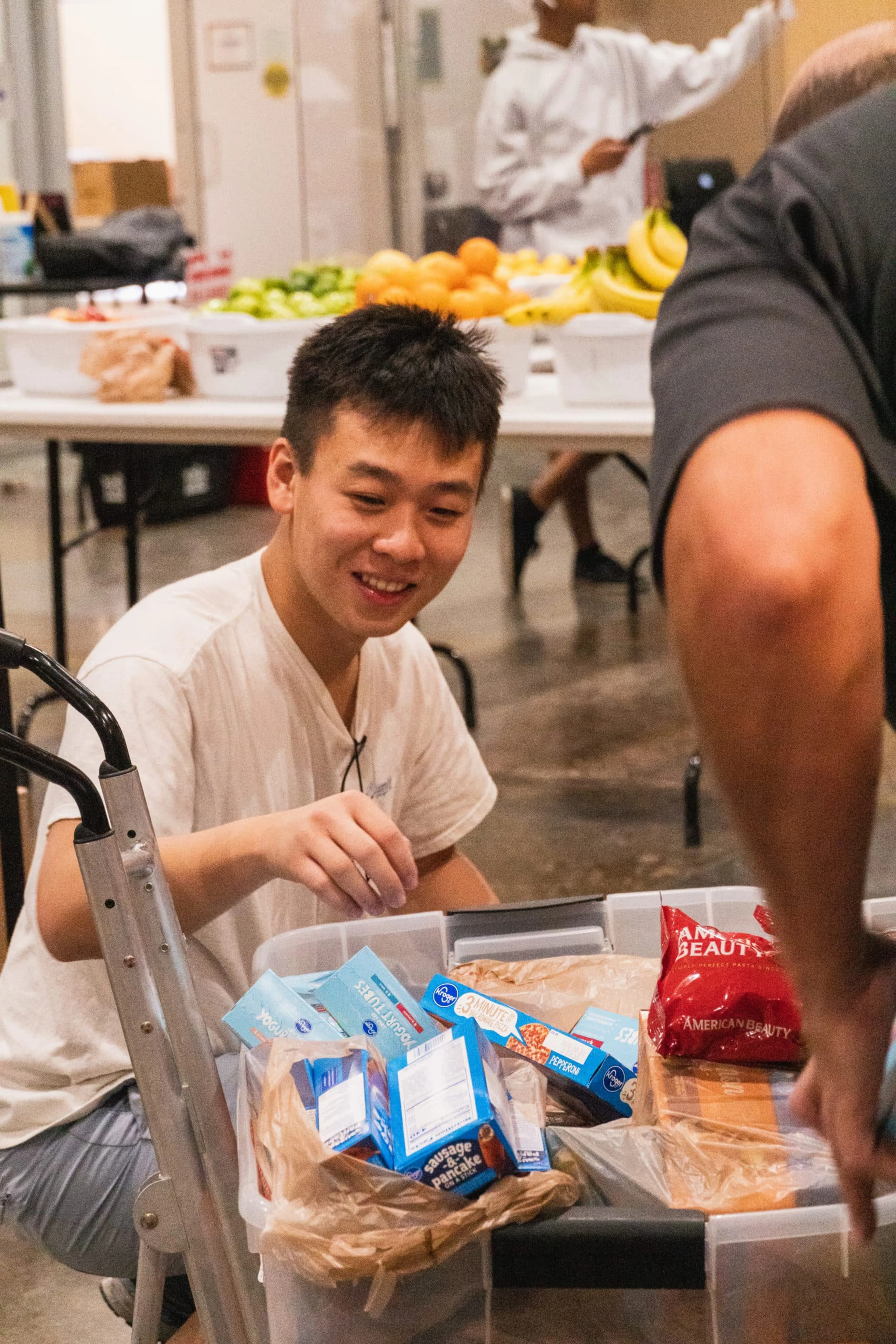 A man organizes food while smiling.