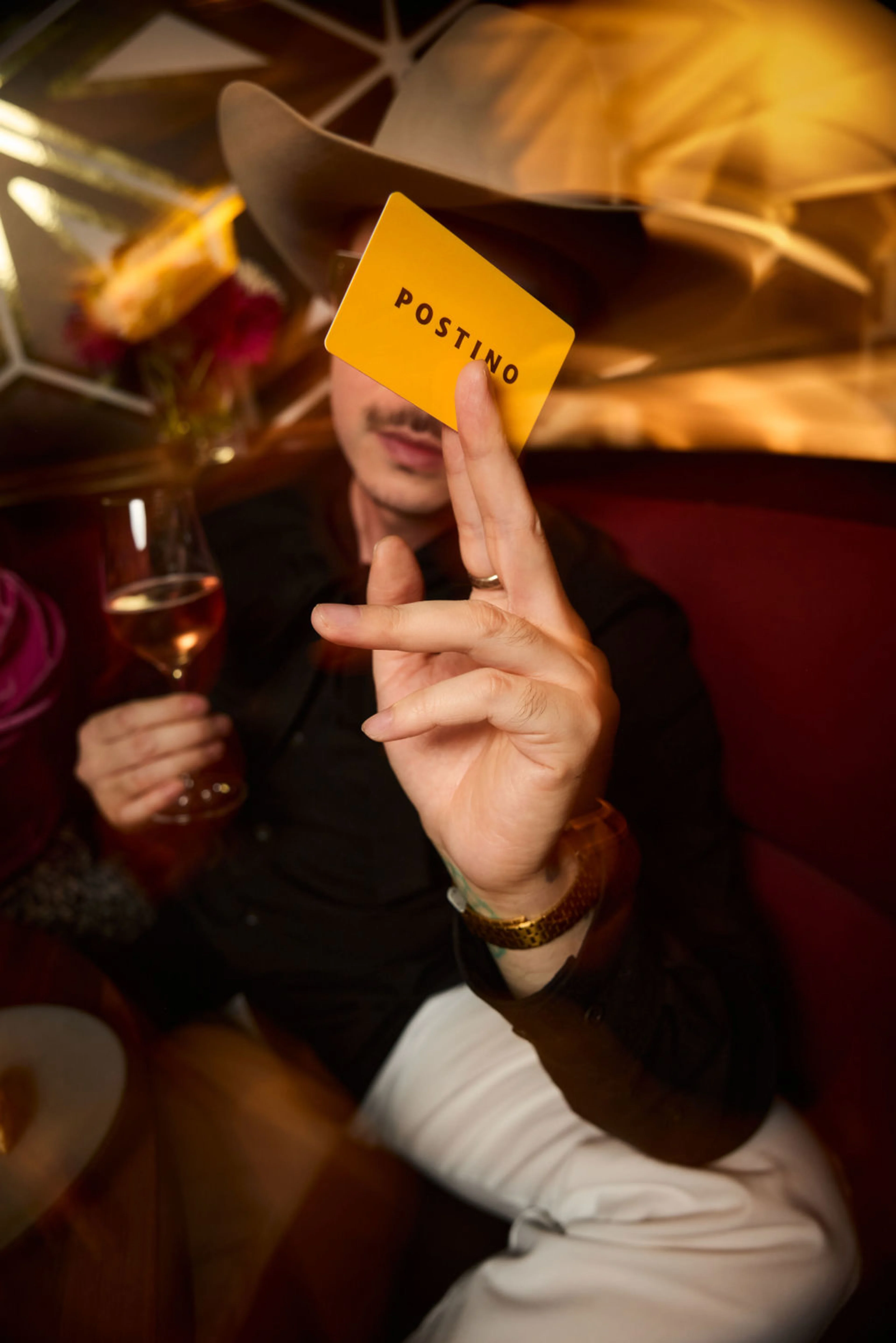 Man holding a gift card, obscuring his face.