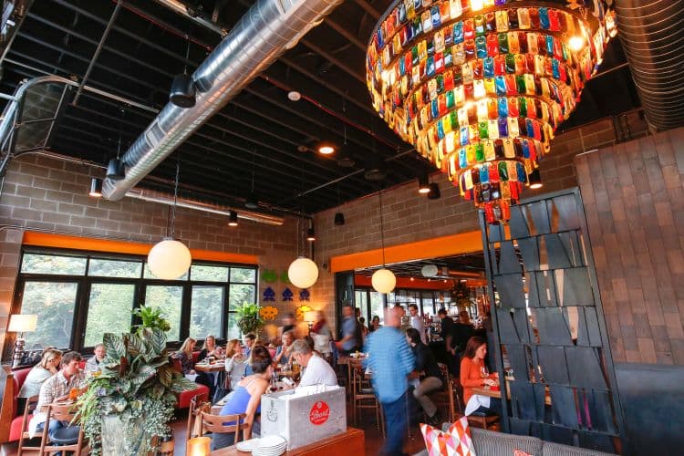 Colorful glass chandelier hanging in a busy restaurant. 