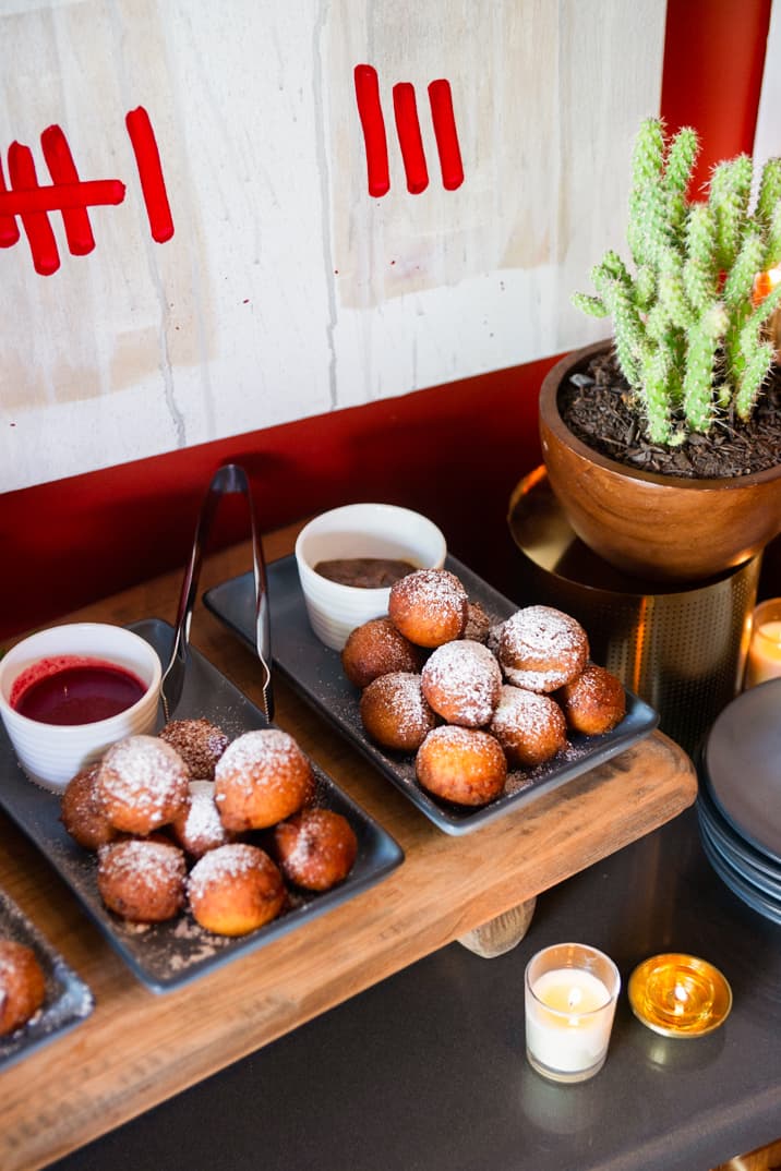 A catering platter full of desserts against a red wall