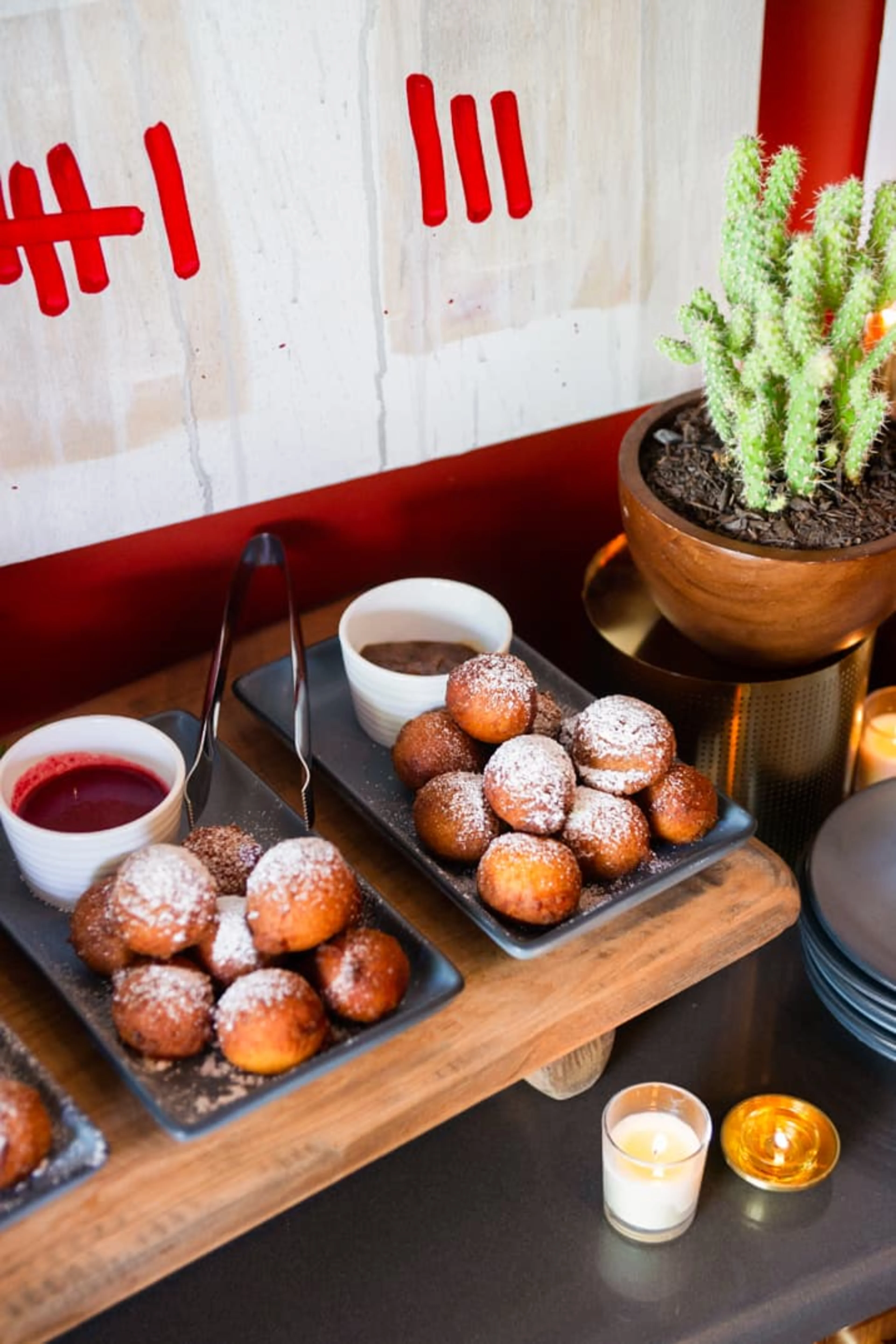 A catering platter full of desserts against a red wall