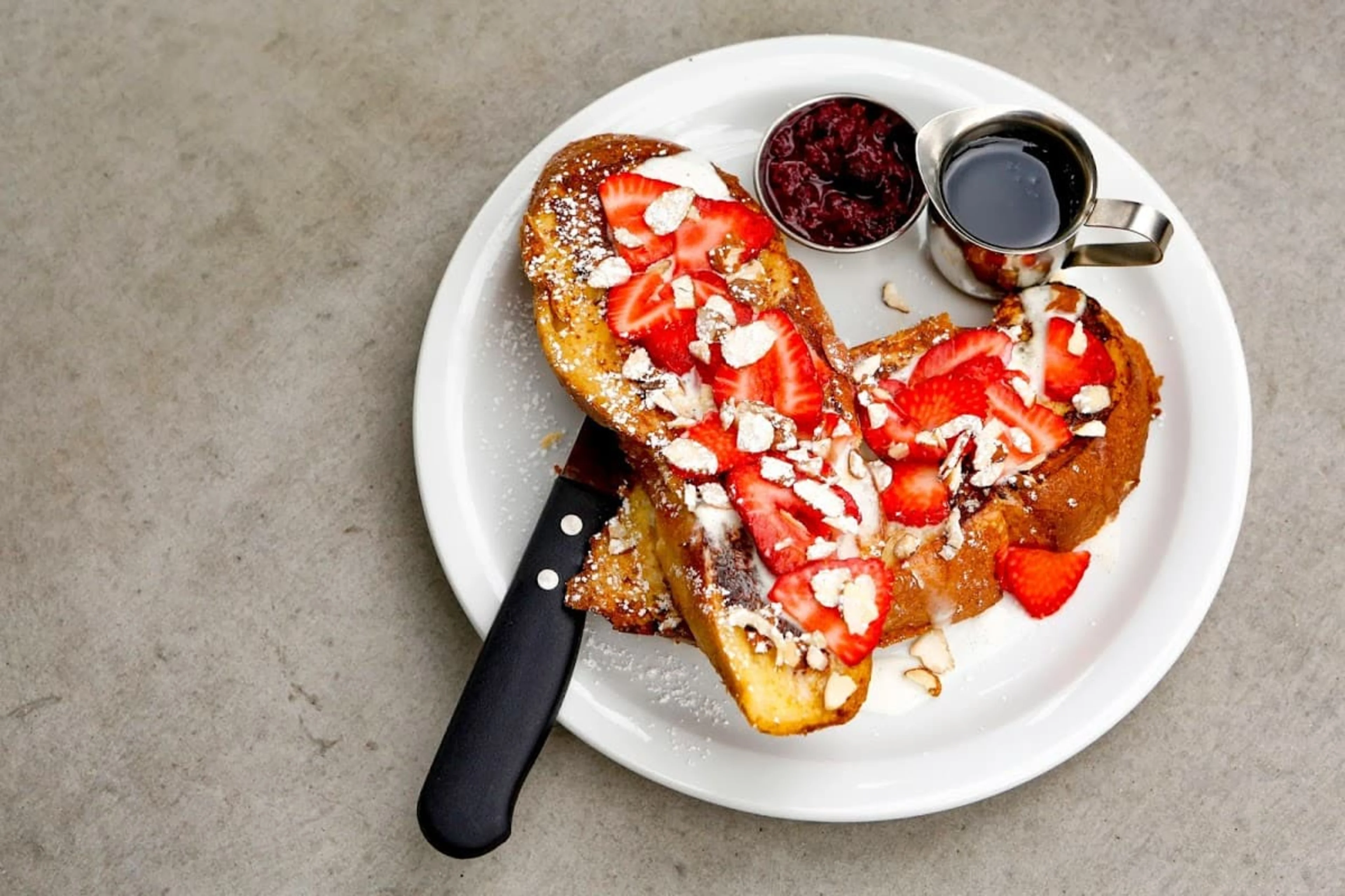 A plate of bruschetta with a knife.