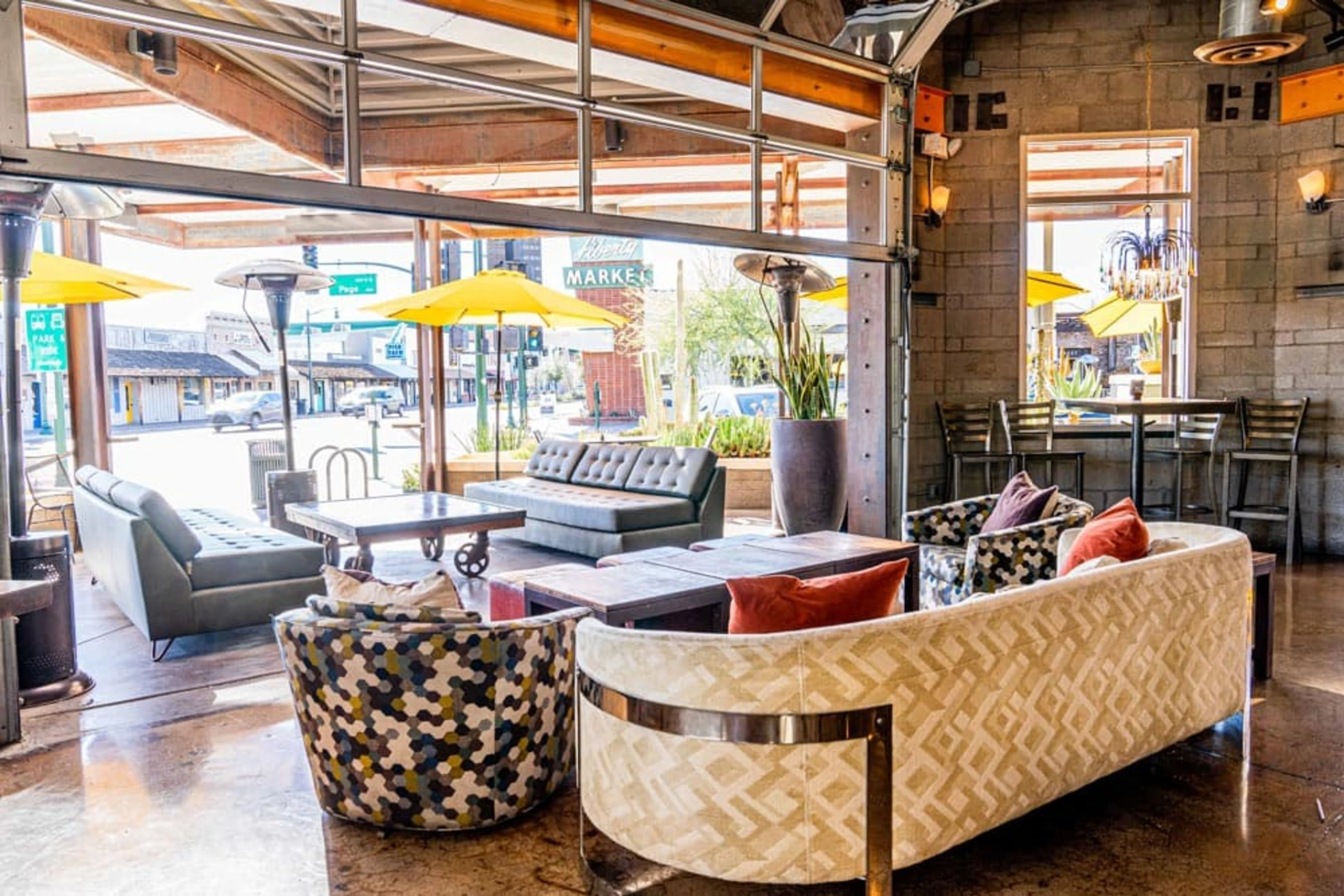 A long white sofa with brightly patterned chairs.