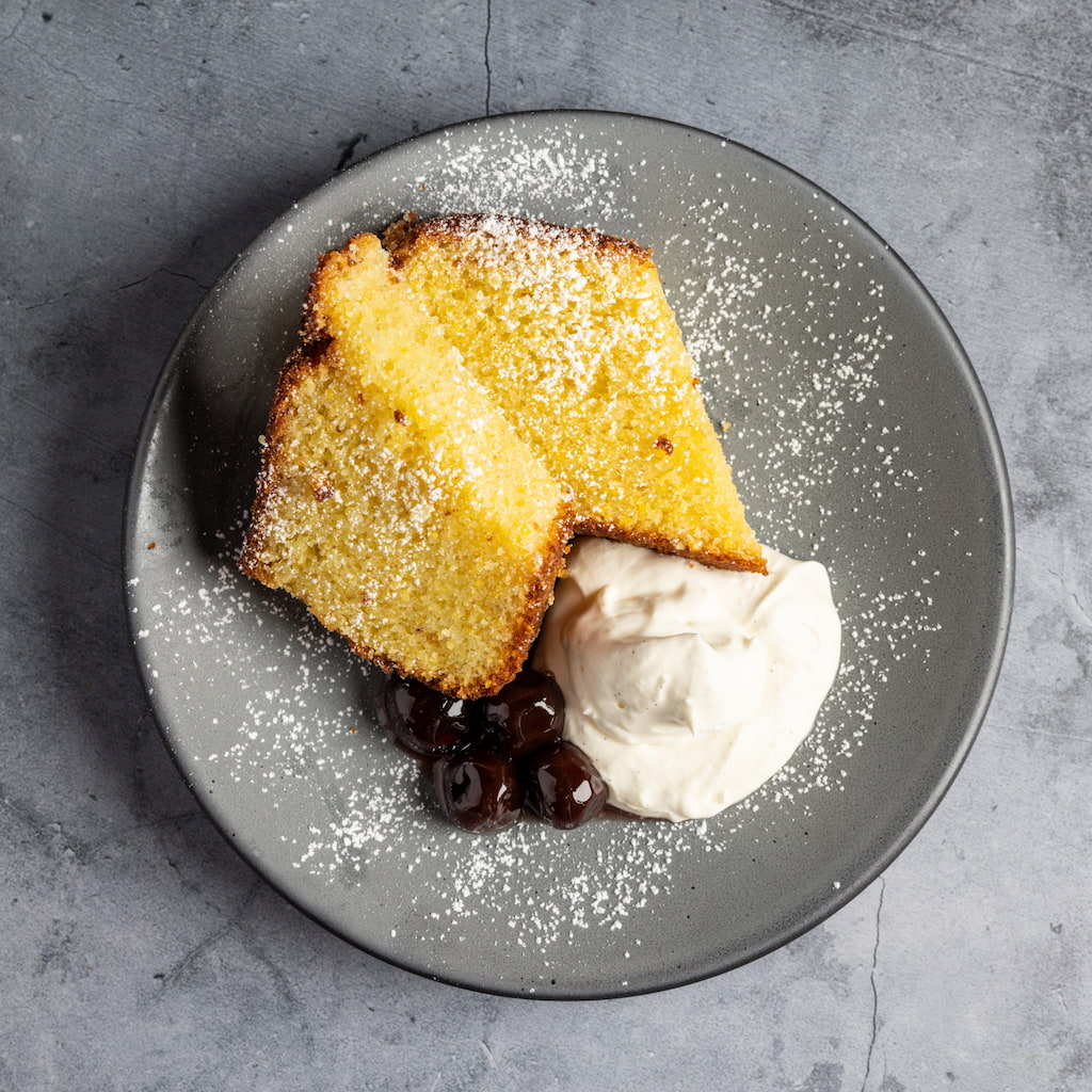 Olive oil cake with house yogurt whip and amarena cherries.