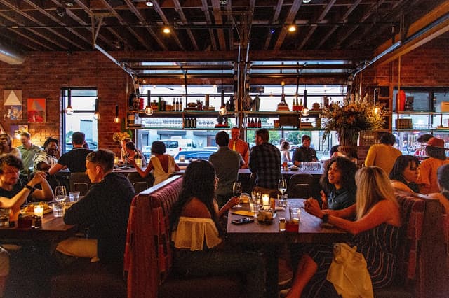 A dimly lit restaurant with booths full of people
