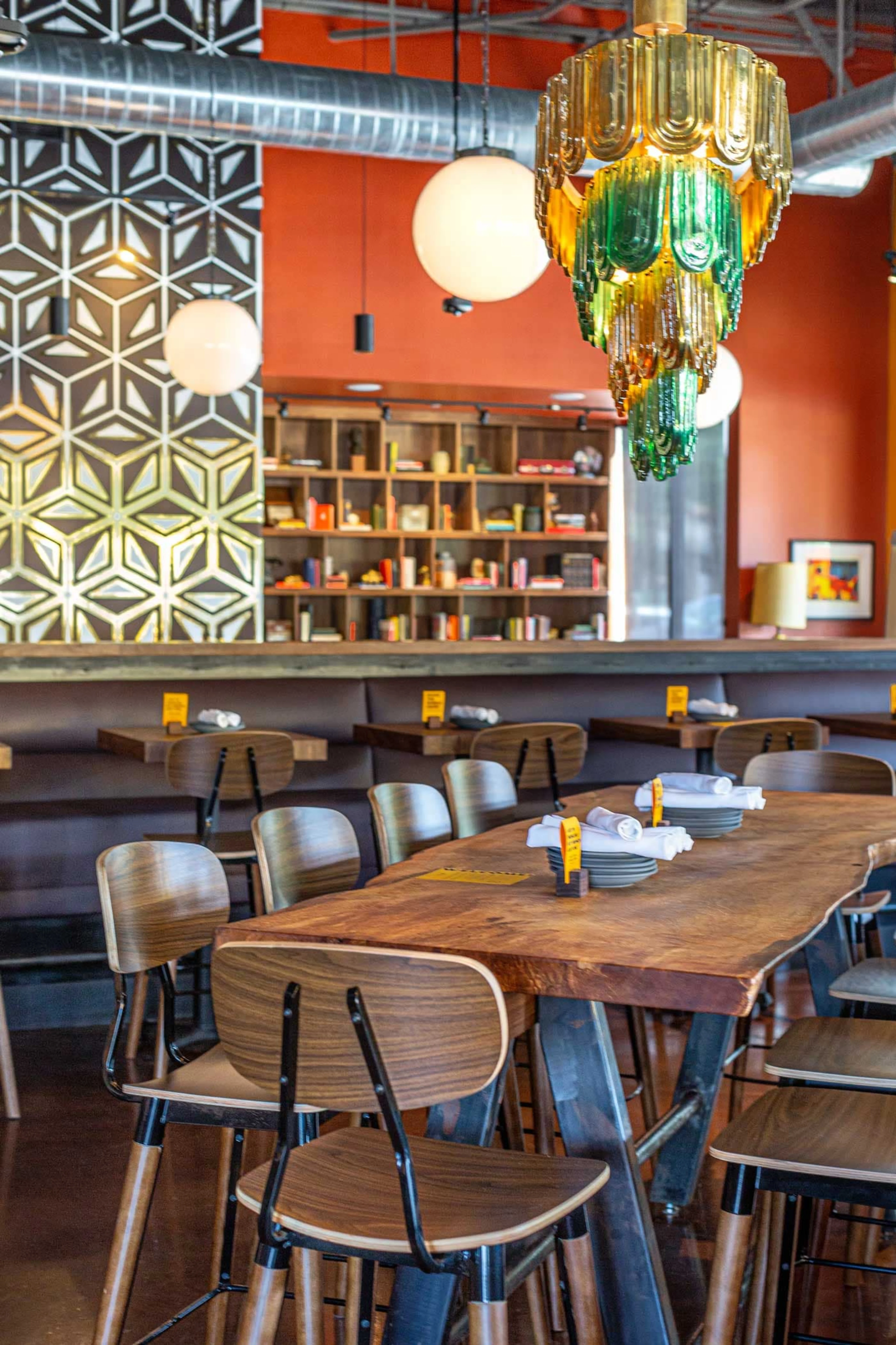 An empty room with a long wooden table and orange walls.
