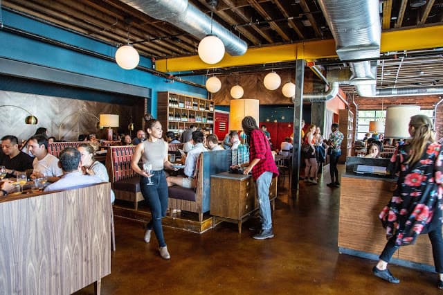 A busy restaurant with servers walking around