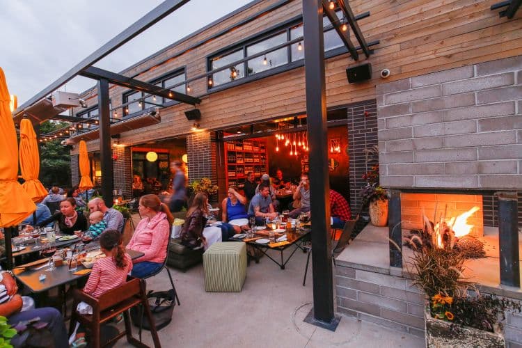Restaurant patio with fireplace and yellow umbrellas.