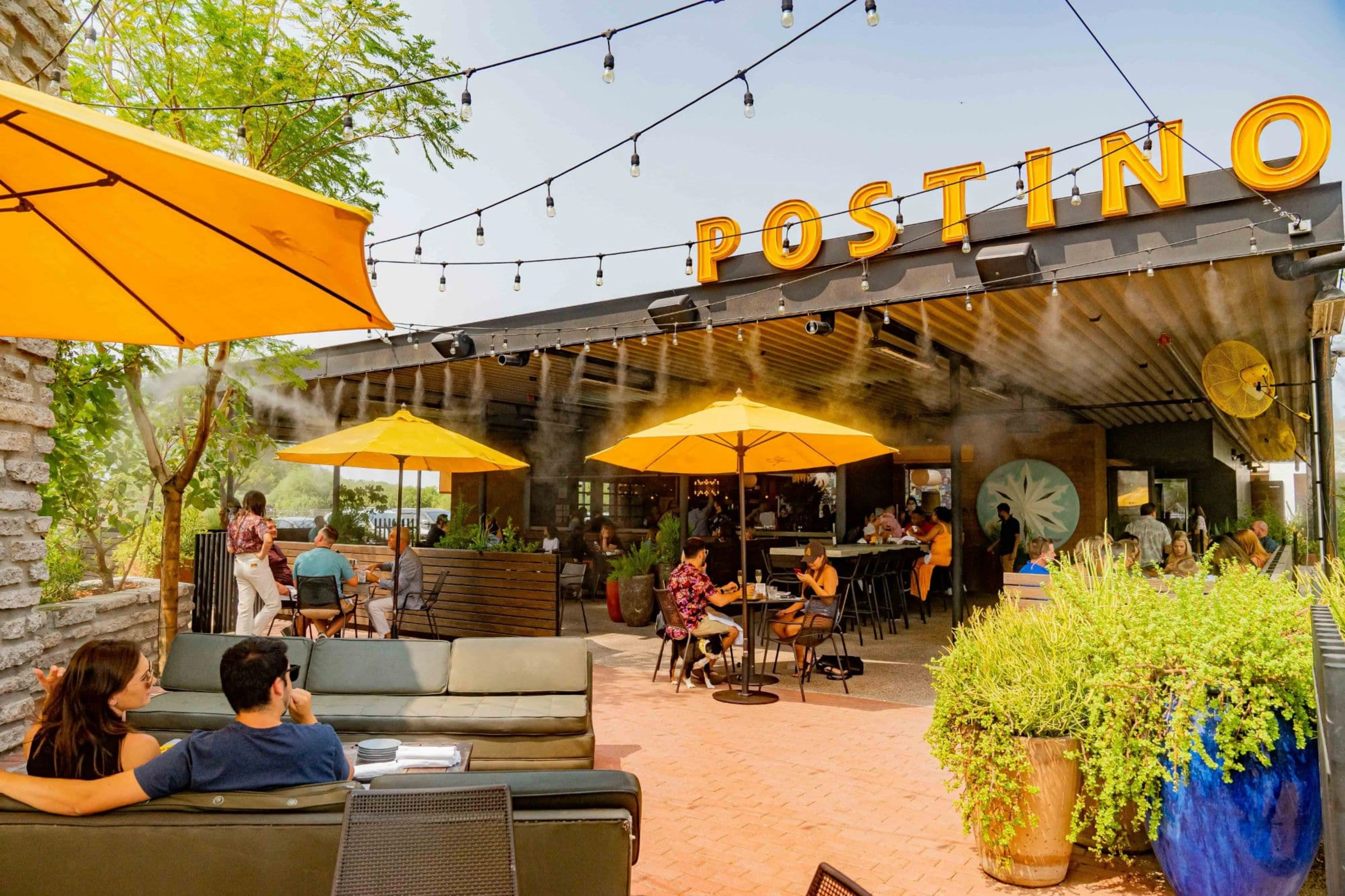 Large restaurant patio with yellow umbrellas and misters.