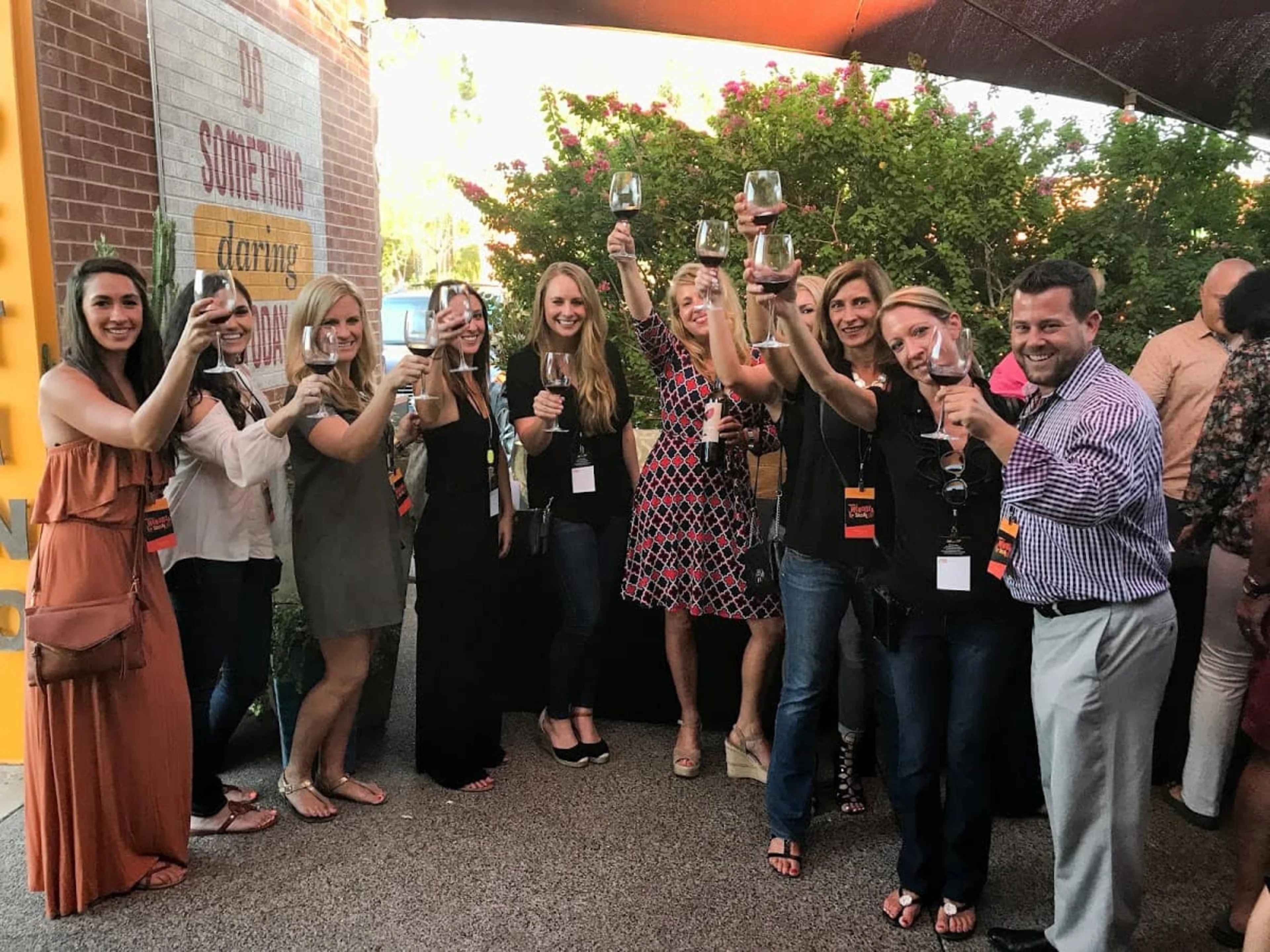 A group of people holding up wine glasses.