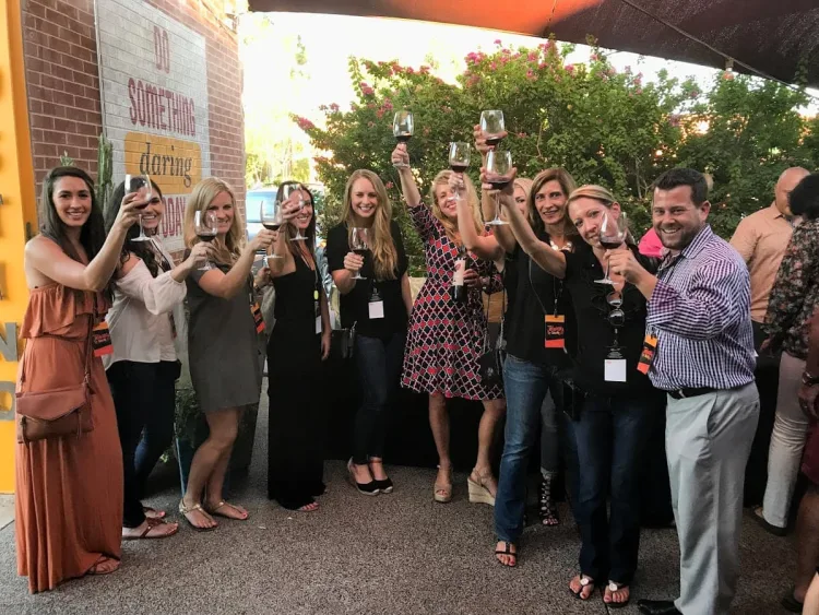 A group of people holding up wine glasses. 