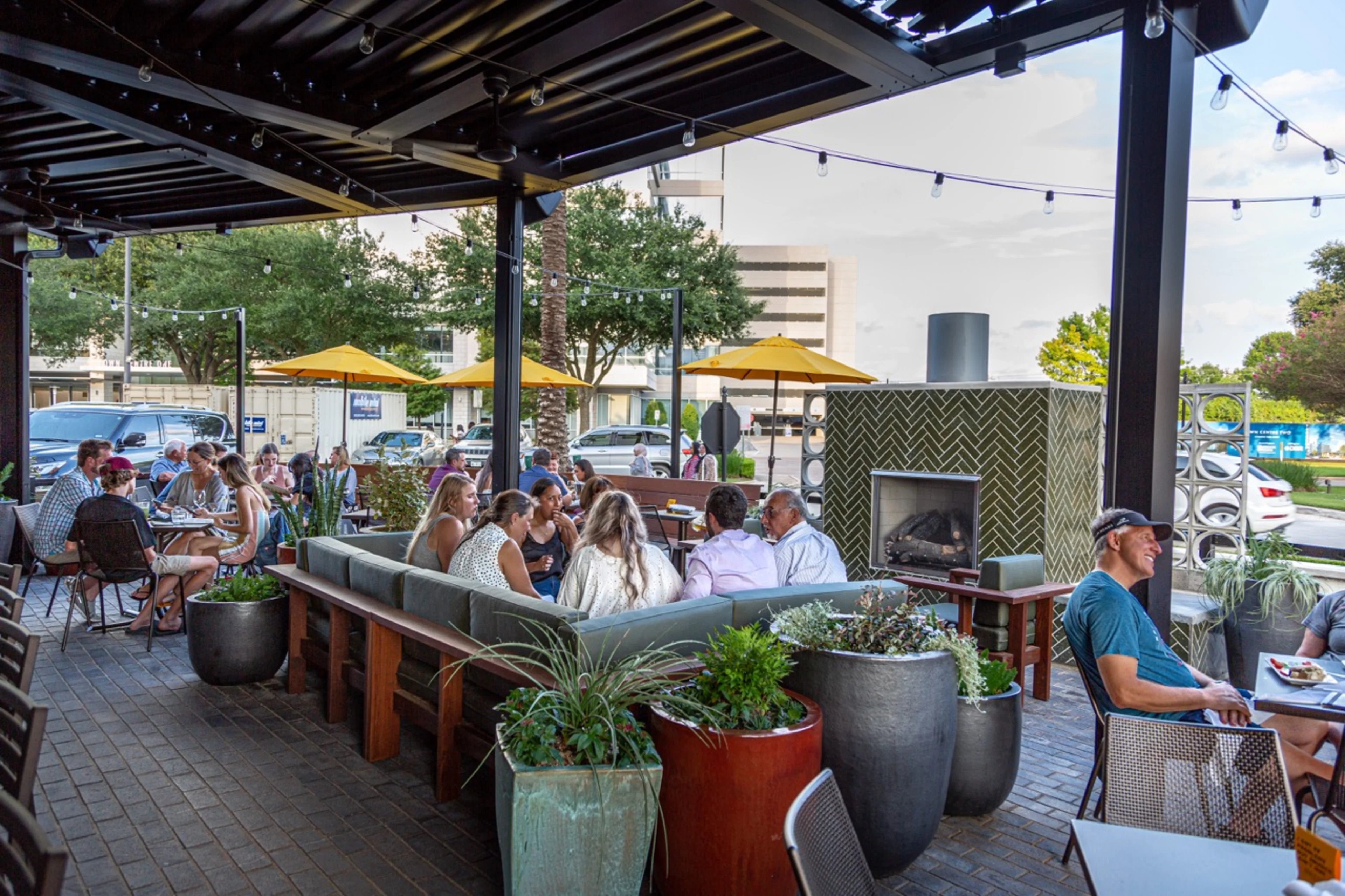 A large brick patio with tables and chairs.