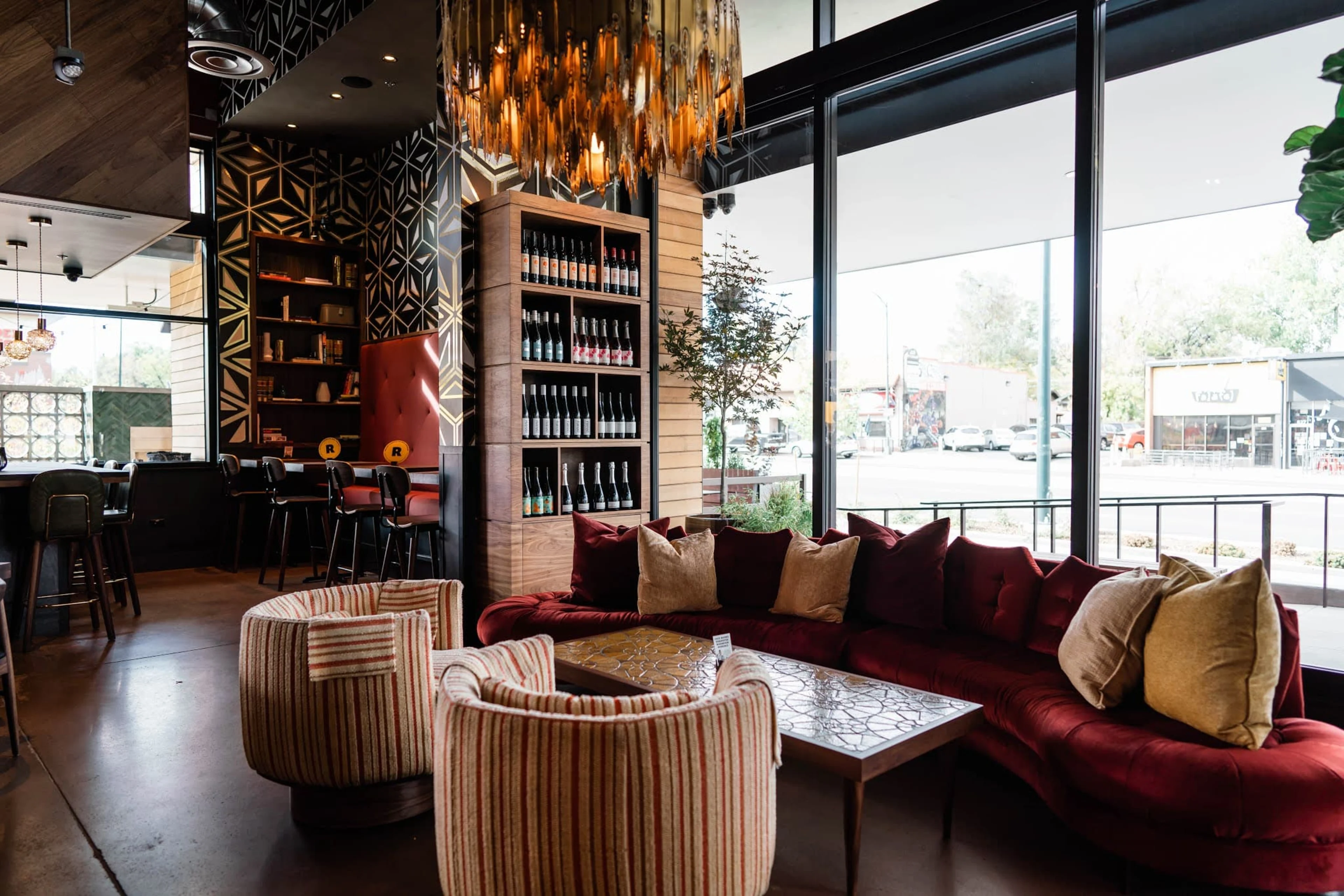 Large windows, red couch, and yellow chandelier.