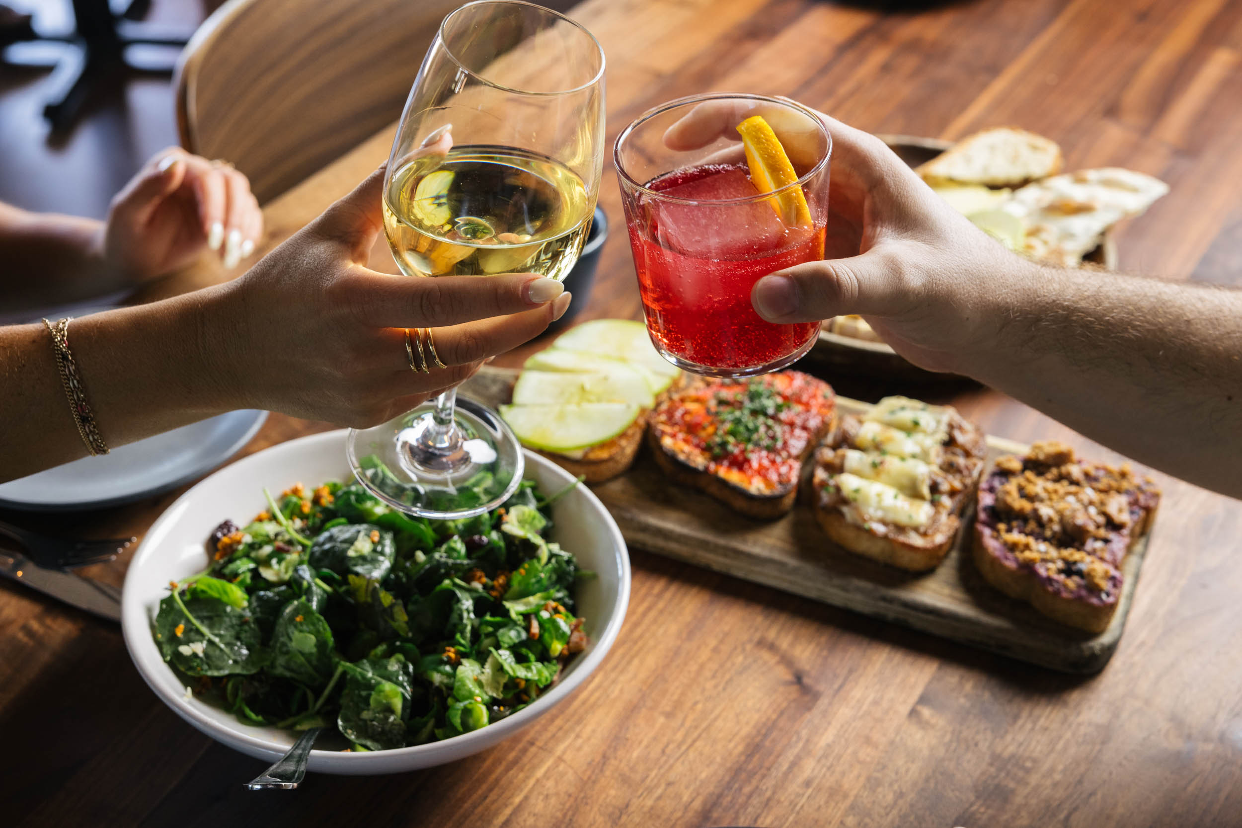 Close up shot of hands toasting wine glasses