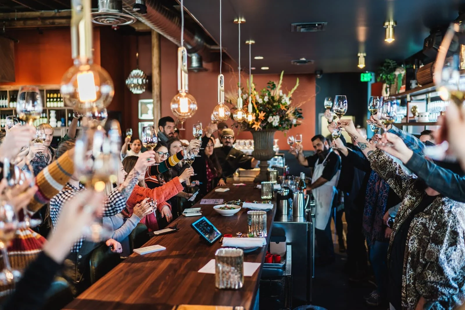 A bar full of people holding their glasses up
