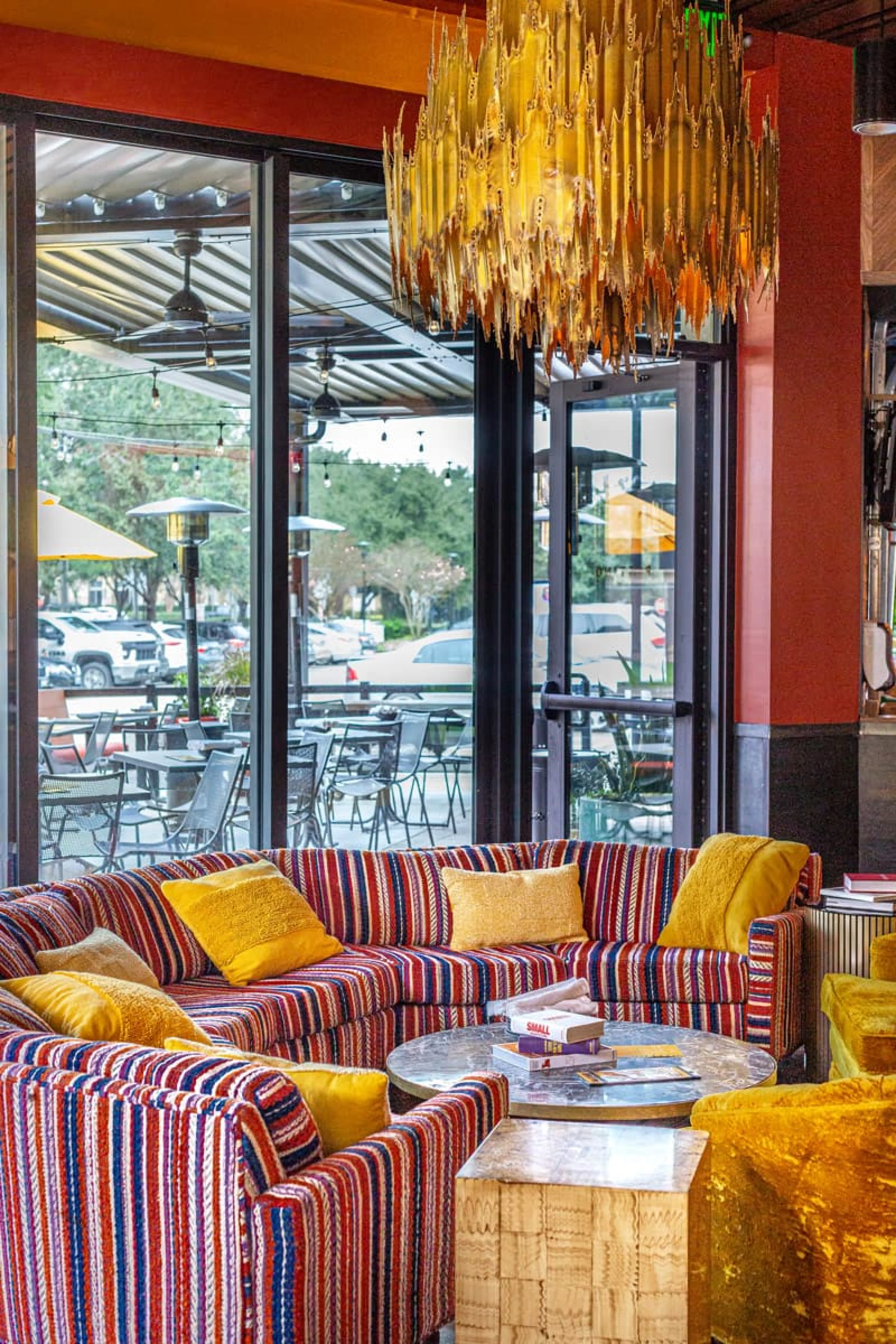 An orange room with a large red-striped couch and floor-to-ceiling windows.
